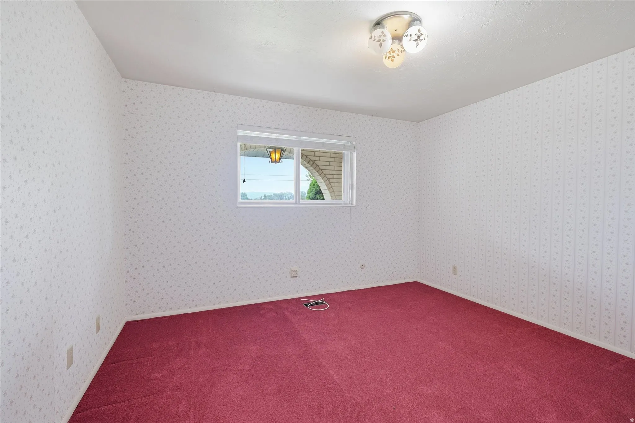 Interior room featuring wall-to-wall red carpeting and patterned wallpaper