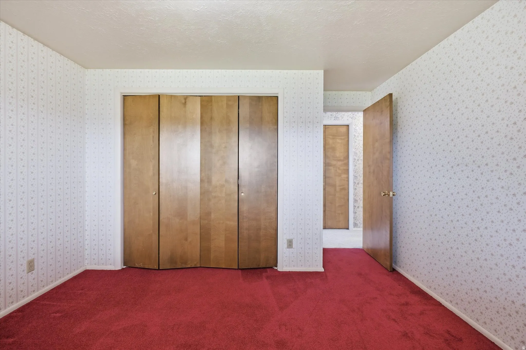 Room featuring red carpeting and patterned wallpaper