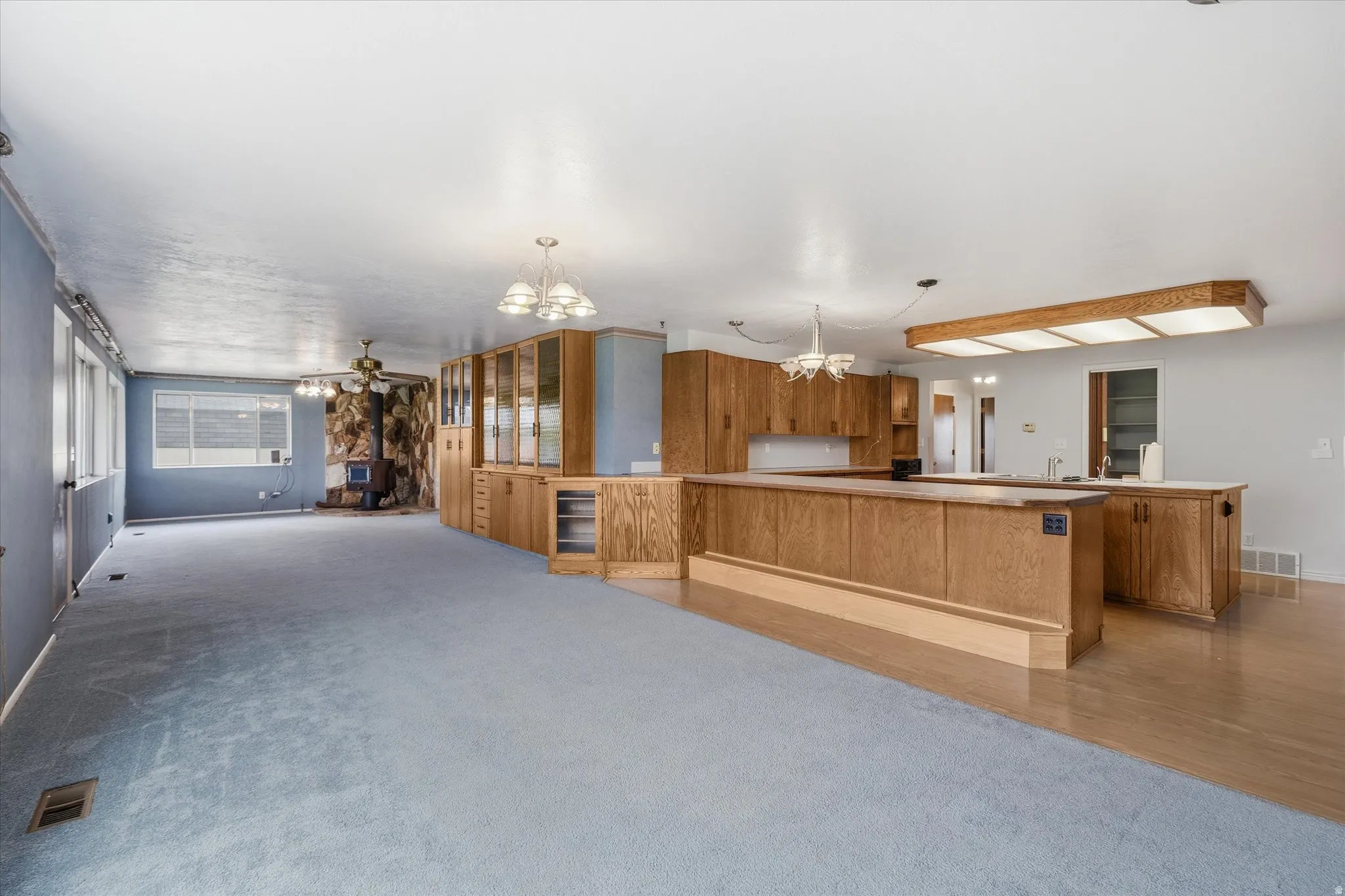 Interior featuring a combination of light blue carpeting and wood-finish flooring