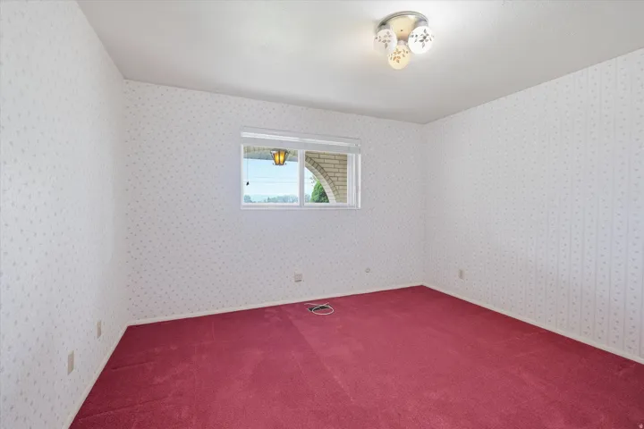 Interior room featuring wall-to-wall red carpeting and patterned wallpaper