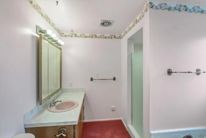 Bathroom vanity with a built-in sink and a three-panel mirrored medicine cabinet