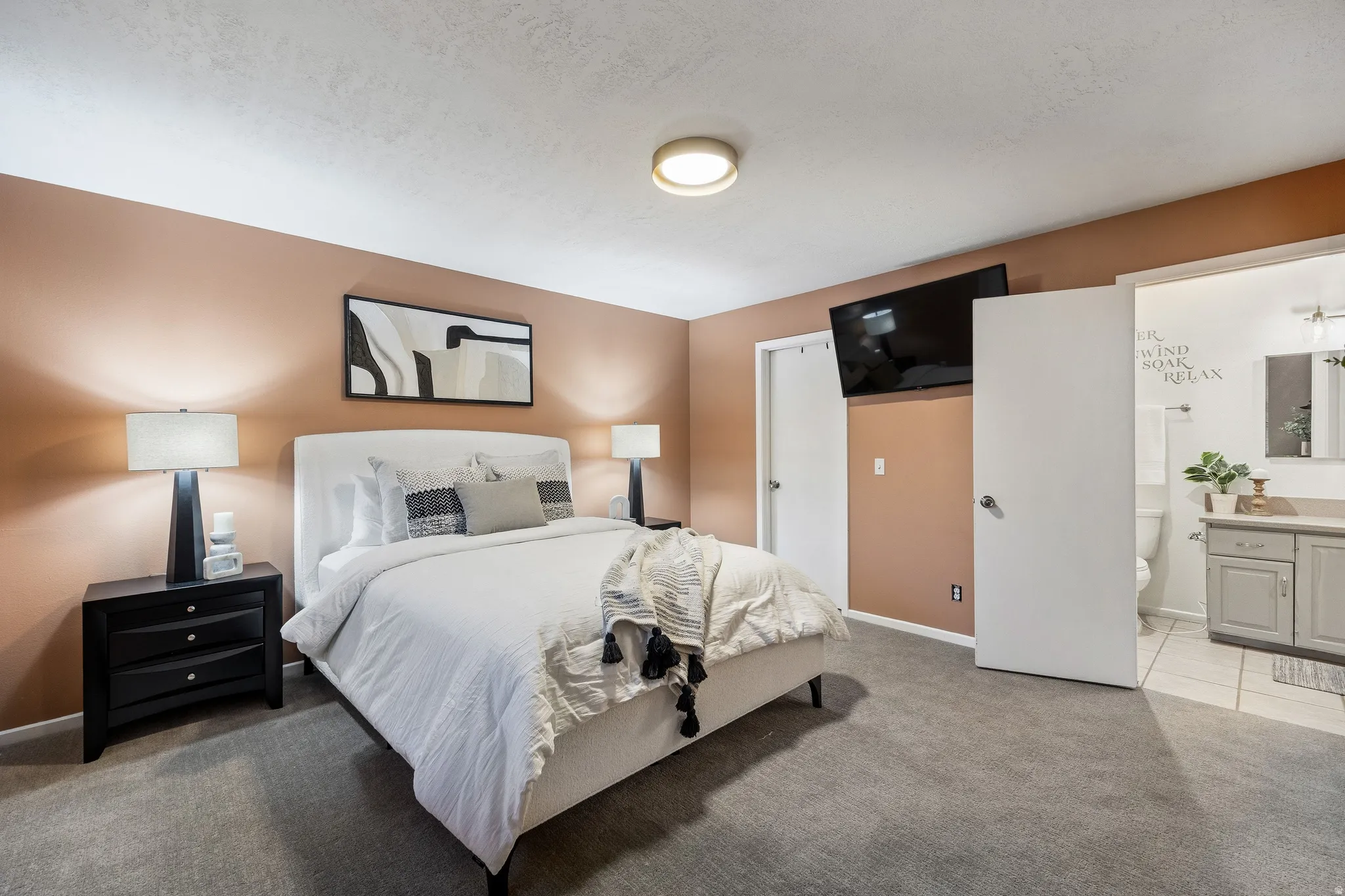 Bedroom featuring warm-toned walls and gray carpeting