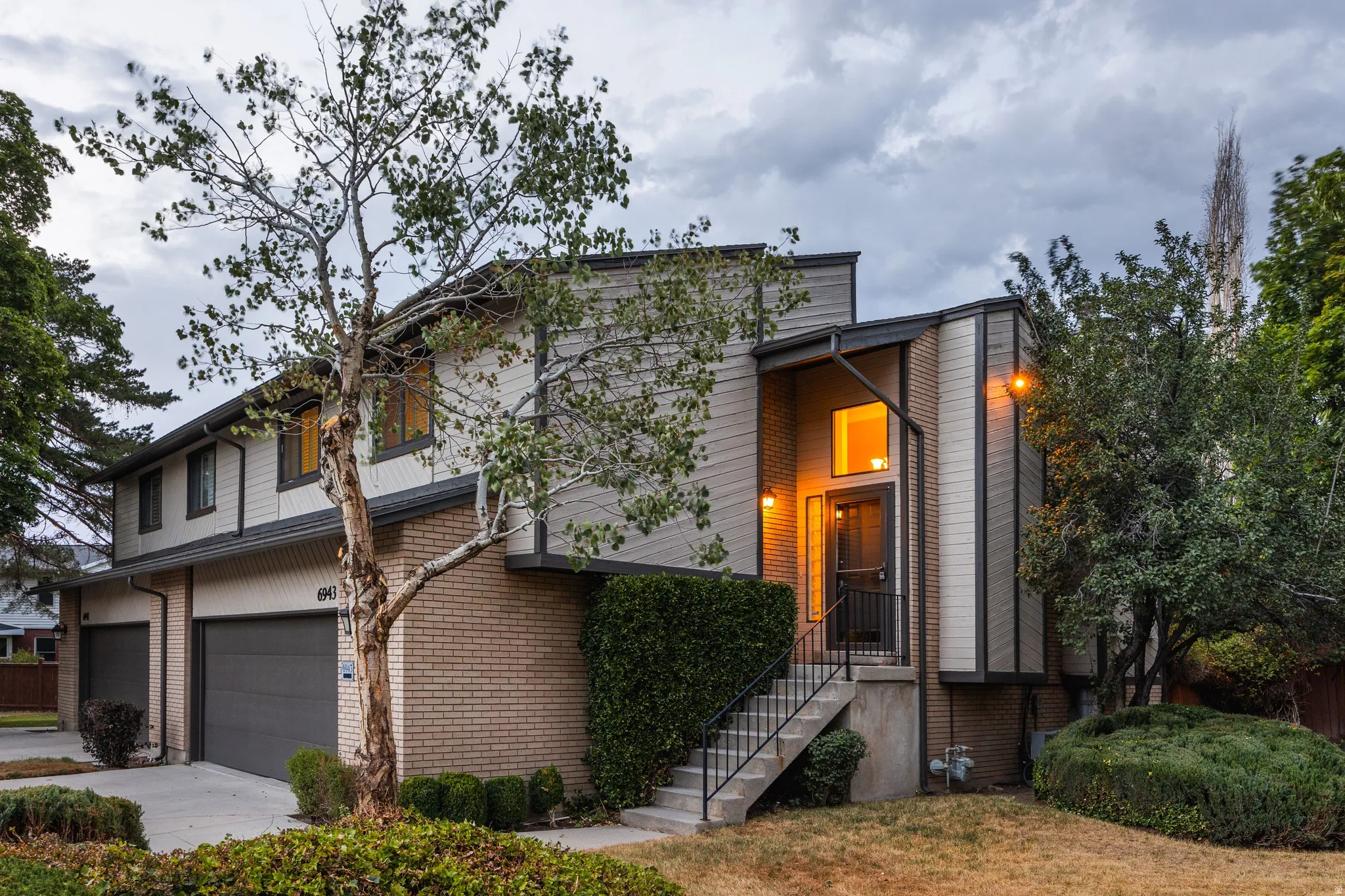Multi-level property exterior featuring brick and vertical siding accents