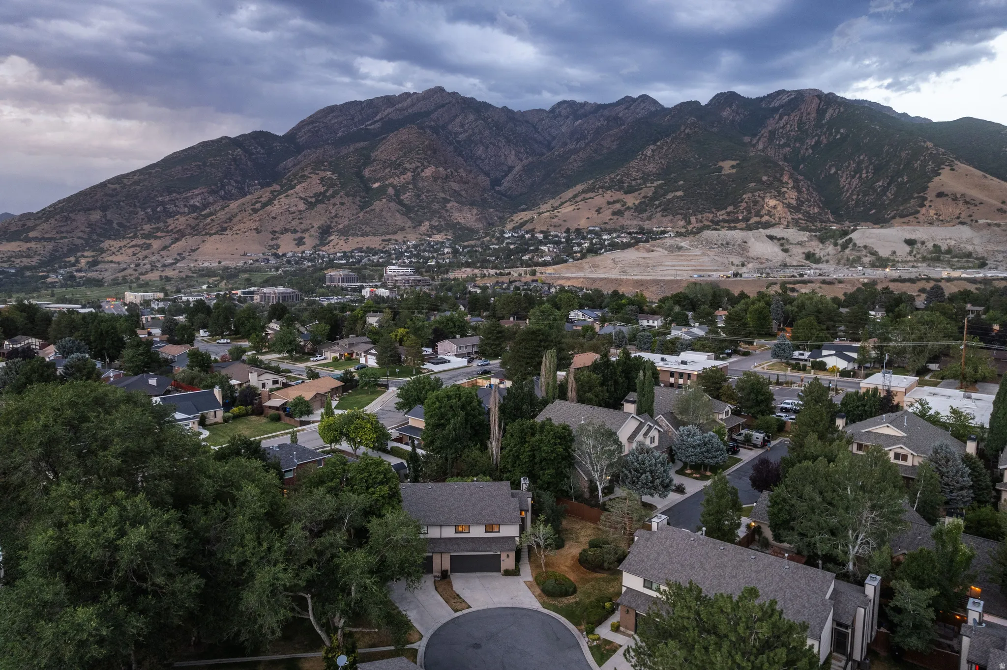 Mountain backdrop overlooking a residential area with mature trees and varied architectural styles