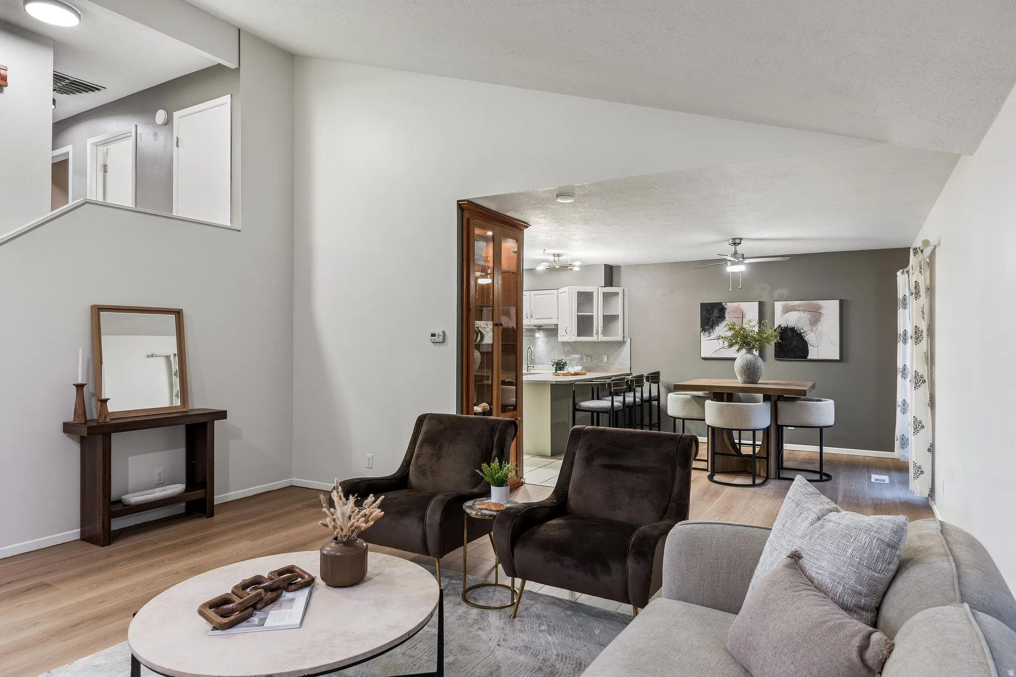 Vaulted ceiling living area with wood-finish flooring