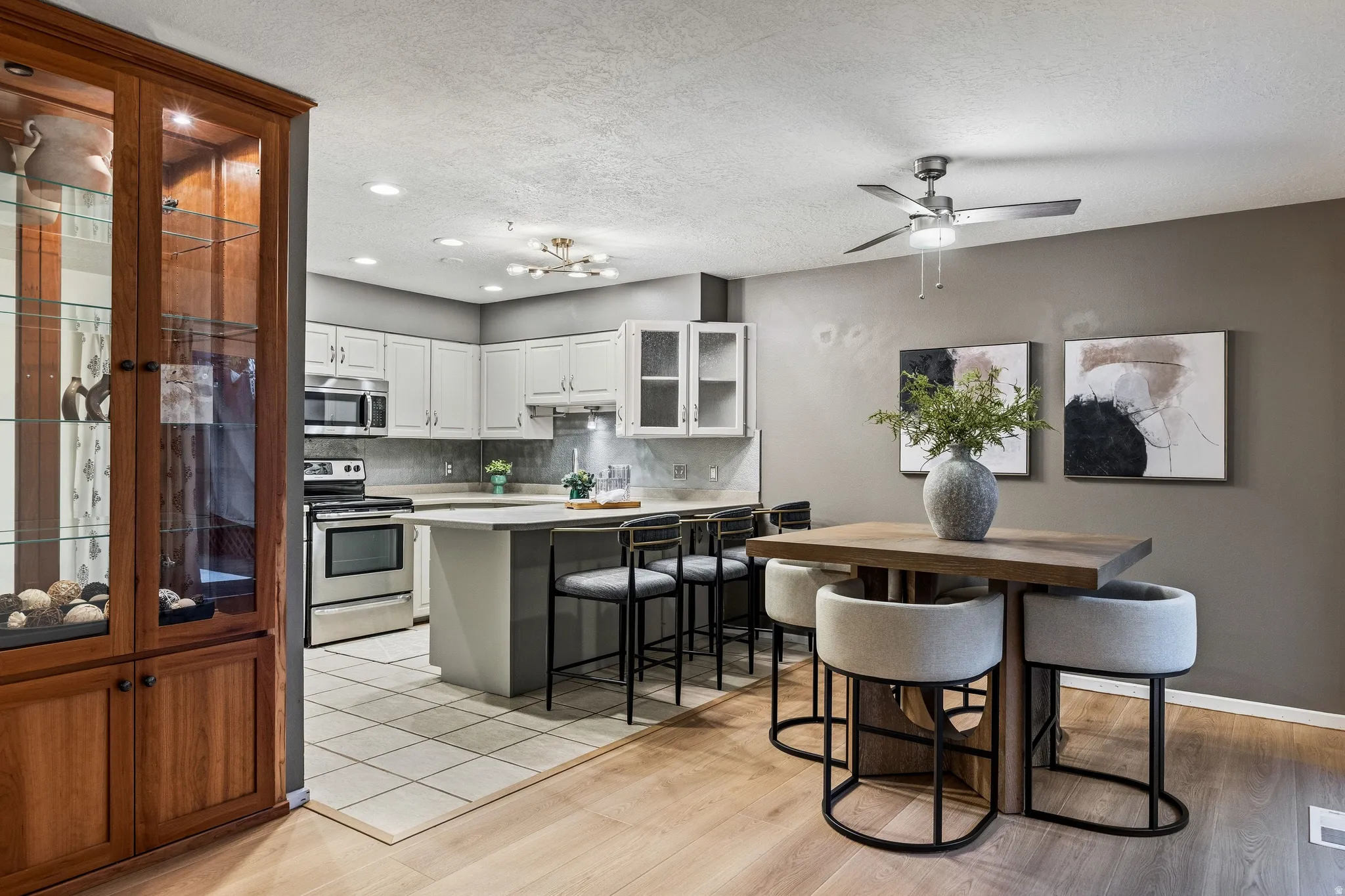 Open-concept dining area featuring wood-finish flooring, a contemporary ceiling fan, and a neutral color palette