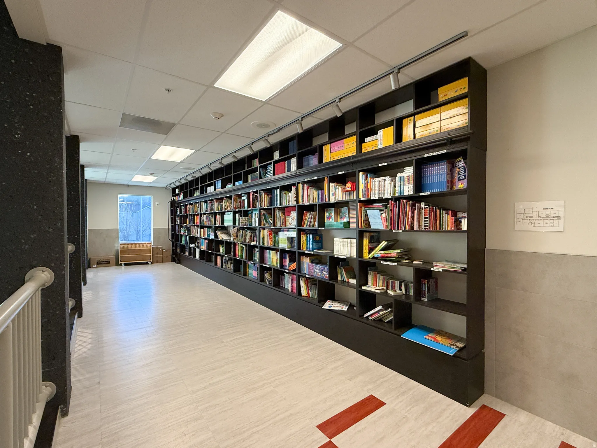 Integrated full-wall shelving system with track lighting