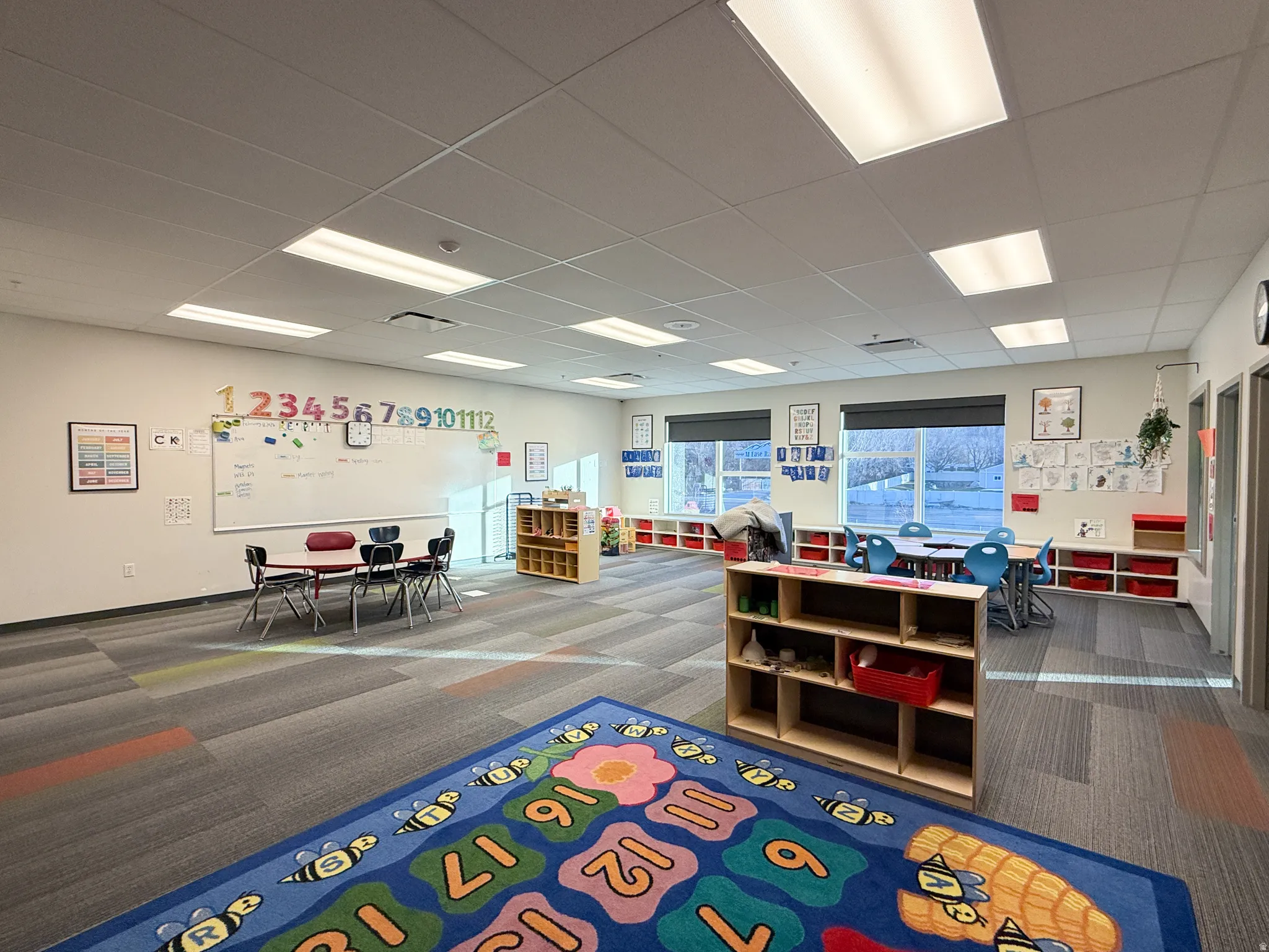 Spacious room featuring multiple large windows, recessed lighting, and patterned carpet flooring