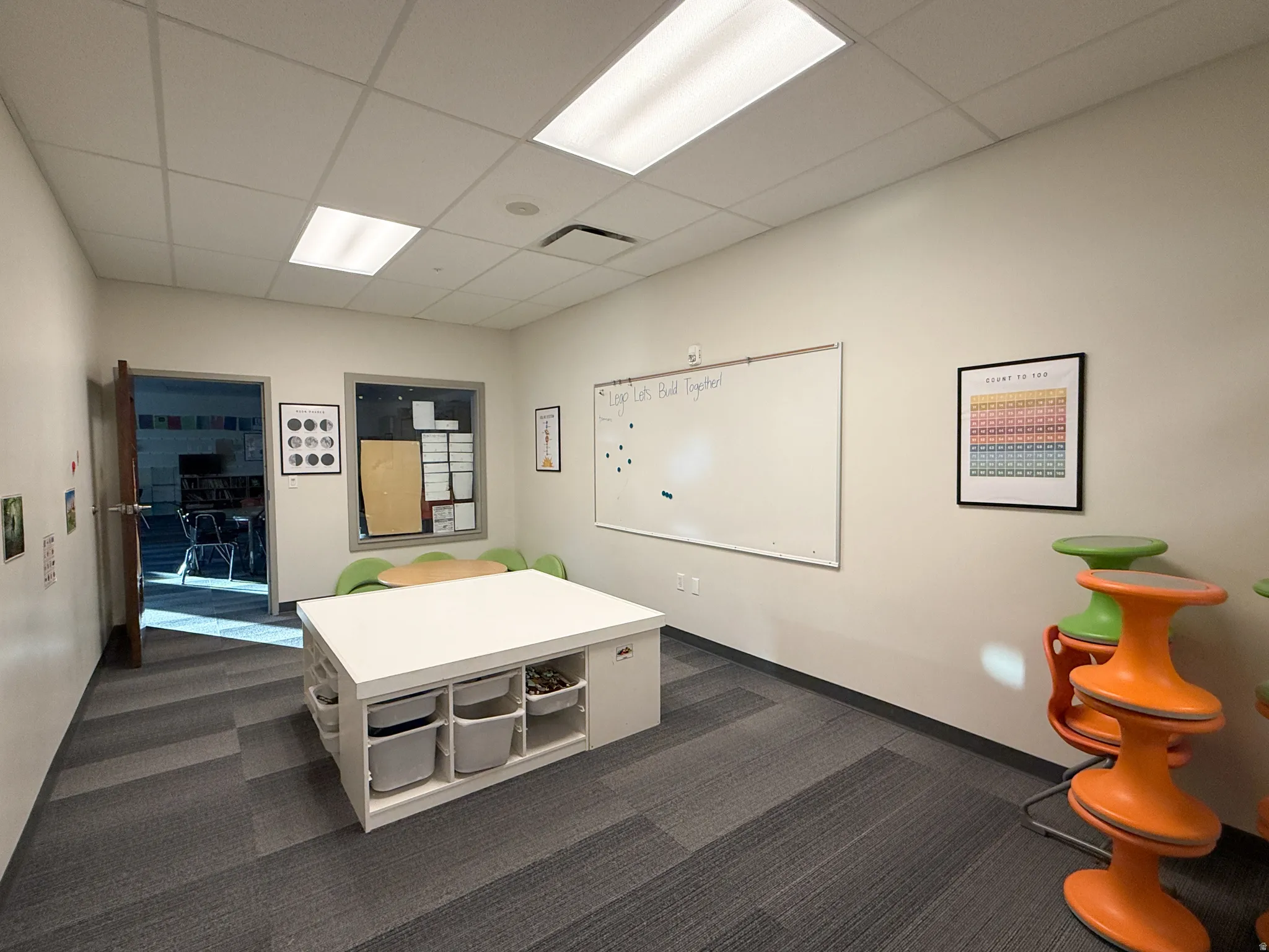 Spacious room featuring neutral wall tones and modular carpet flooring
