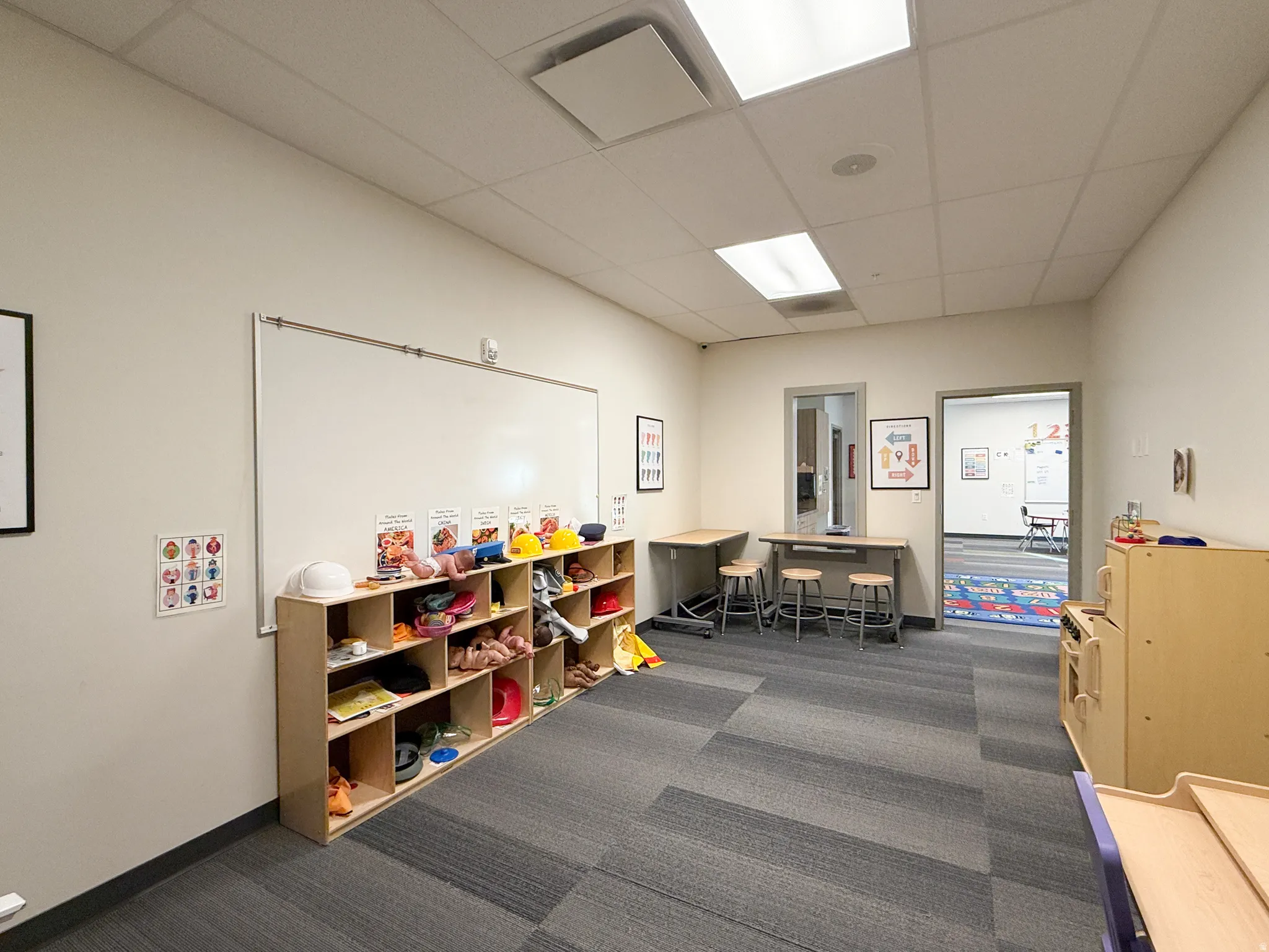 Spacious room featuring modular carpet flooring, neutral wall tones, and recessed lighting