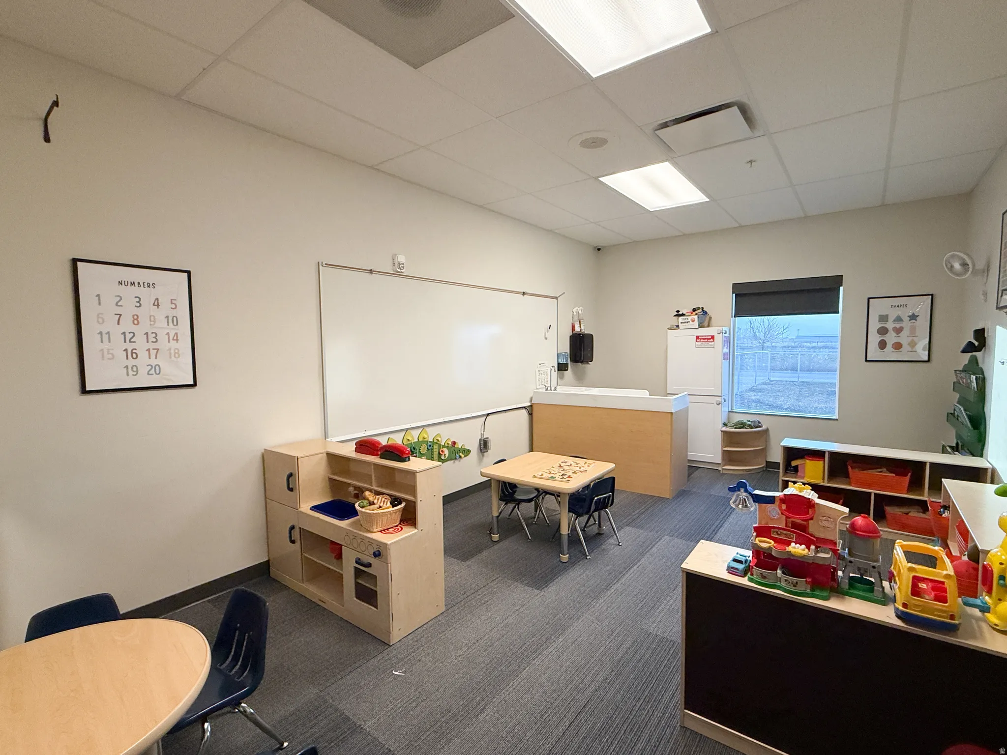 Spacious room featuring neutral paint, a large whiteboard, recessed lighting, and carpet flooring