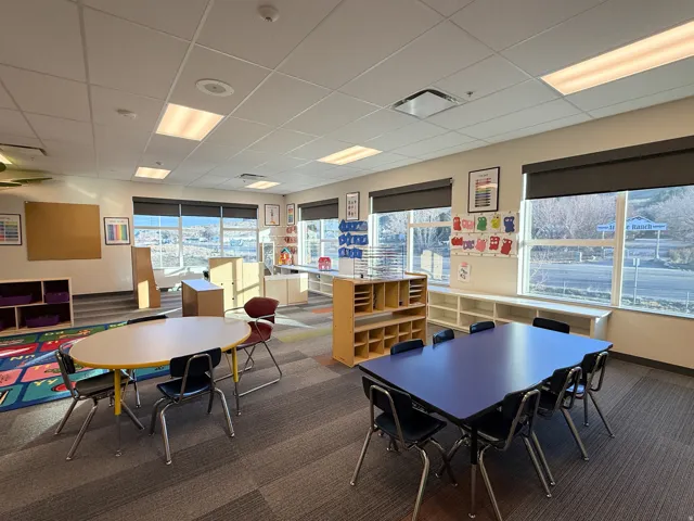 Spacious room featuring multiple large windows with roller shades, recessed lighting, and modular carpet flooring