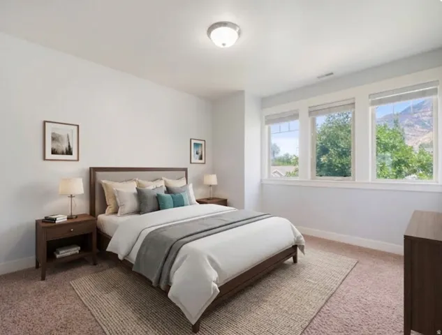 Light-filled room featuring three large windows, a neutral color palette, and carpet flooring