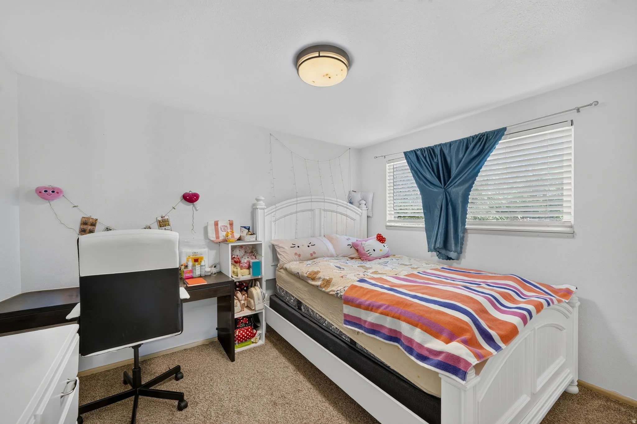 Bedroom featuring neutral wall paint, a window with horizontal blinds, and a built-in flush mount light fixture