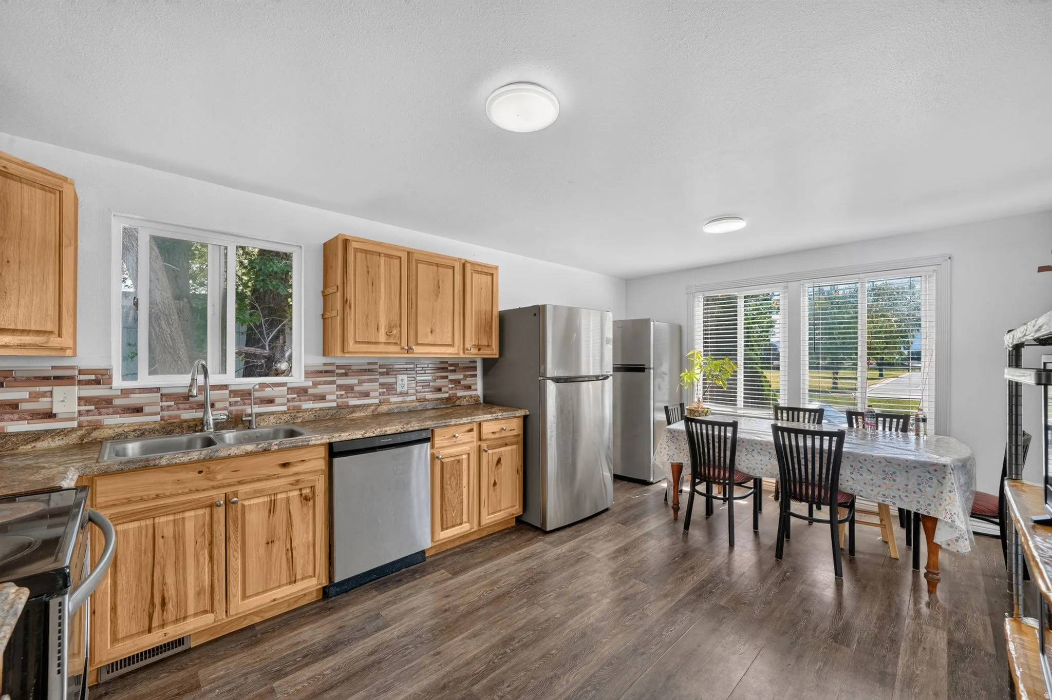 Kitchen featuring wood cabinetry, granite-style countertops, and a mosaic tile backsplash