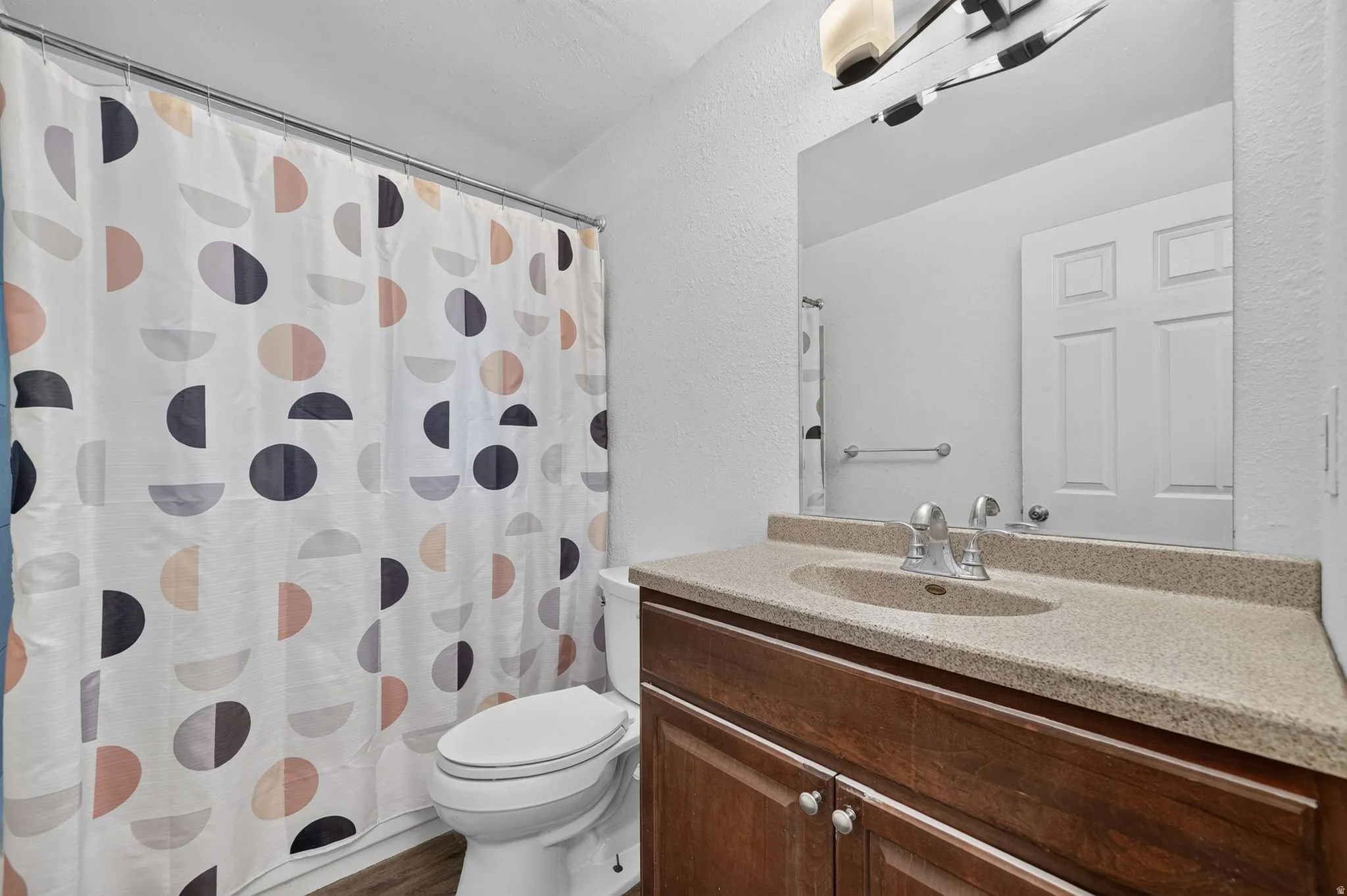 Bathroom vanity featuring a light-toned countertop with integrated sink and chrome faucet