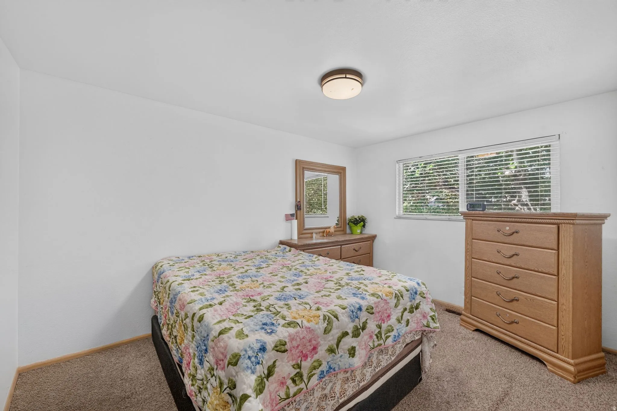 Bedroom featuring a window with blinds, a flush mount ceiling light, and wall-to-wall carpeting