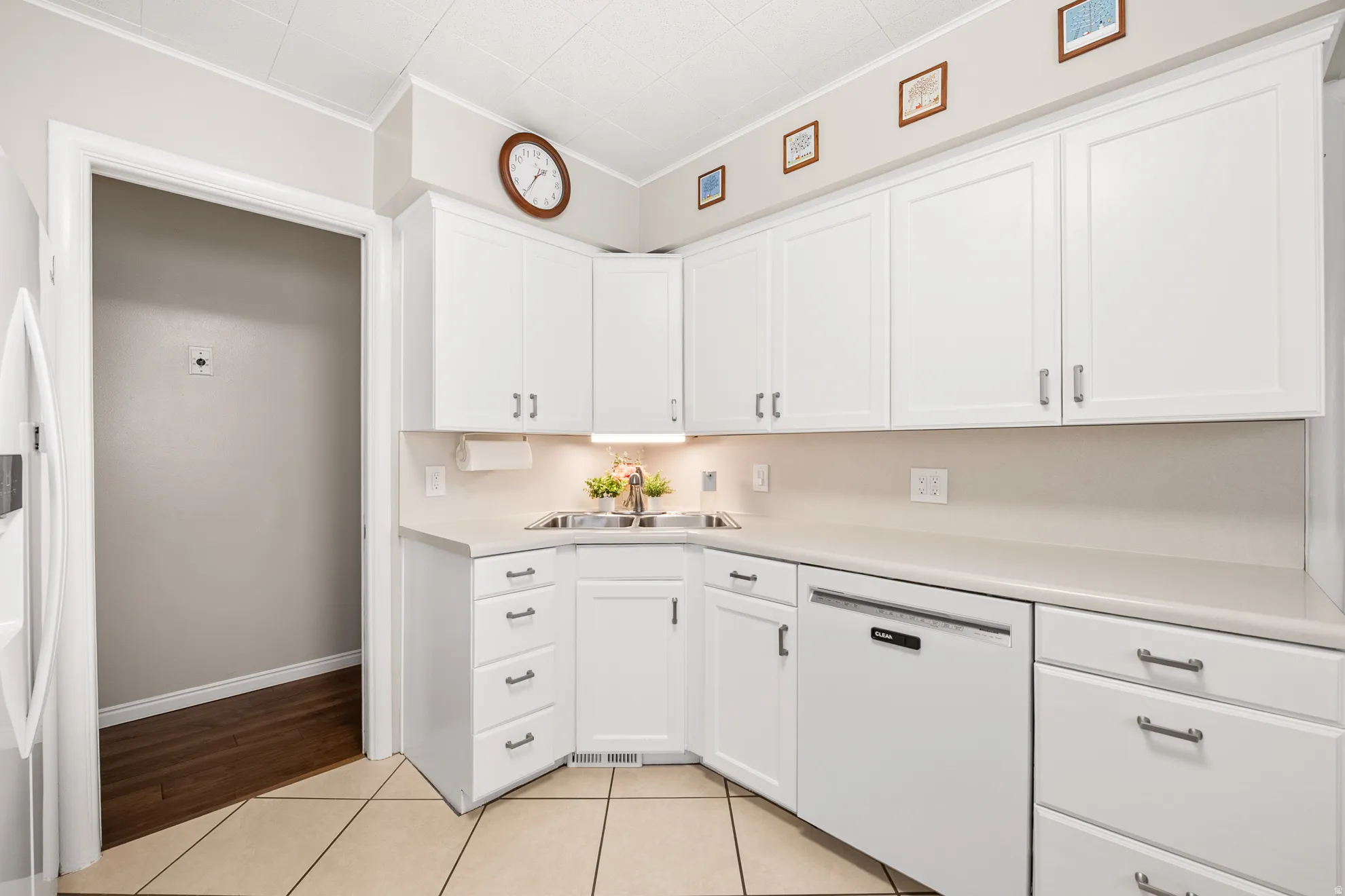 Kitchen featuring white cabinetry, light countertops, and a stainless steel sink