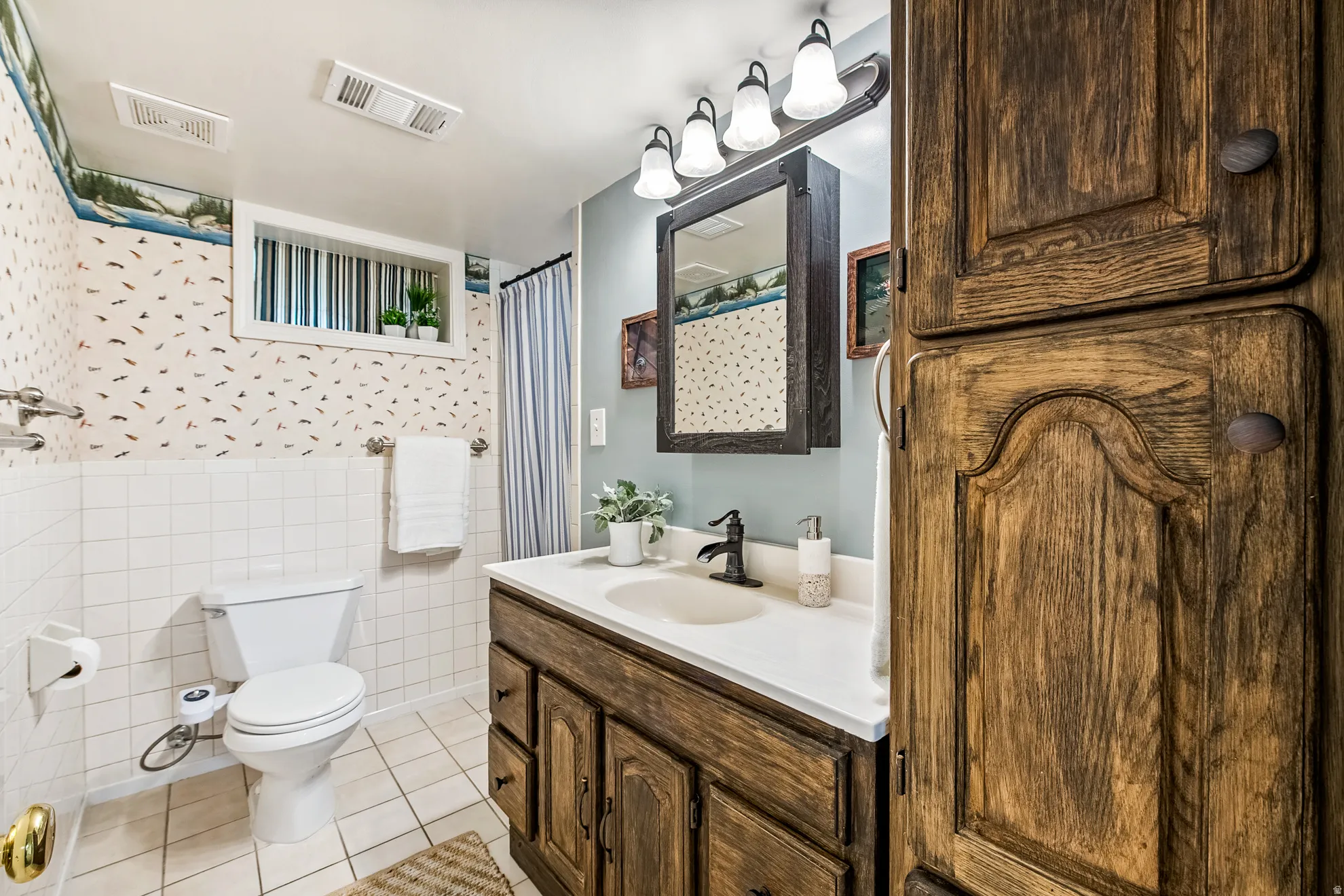 Bathroom featuring a wood-finish vanity with an integrated sink, white countertop, and a dark bronze faucet