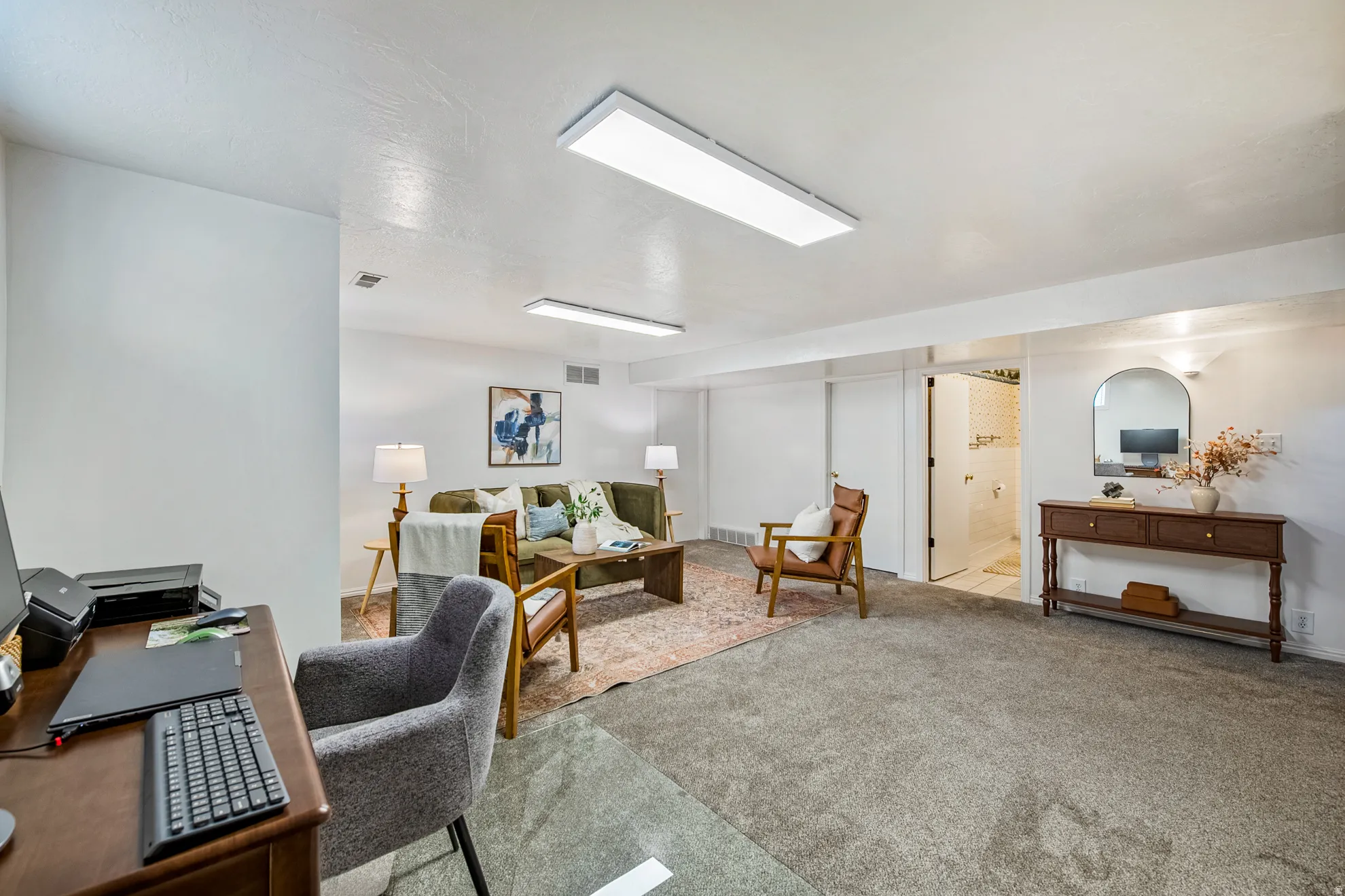 Spacious room featuring neutral carpet flooring, recessed lighting, white walls, and a built-in archway