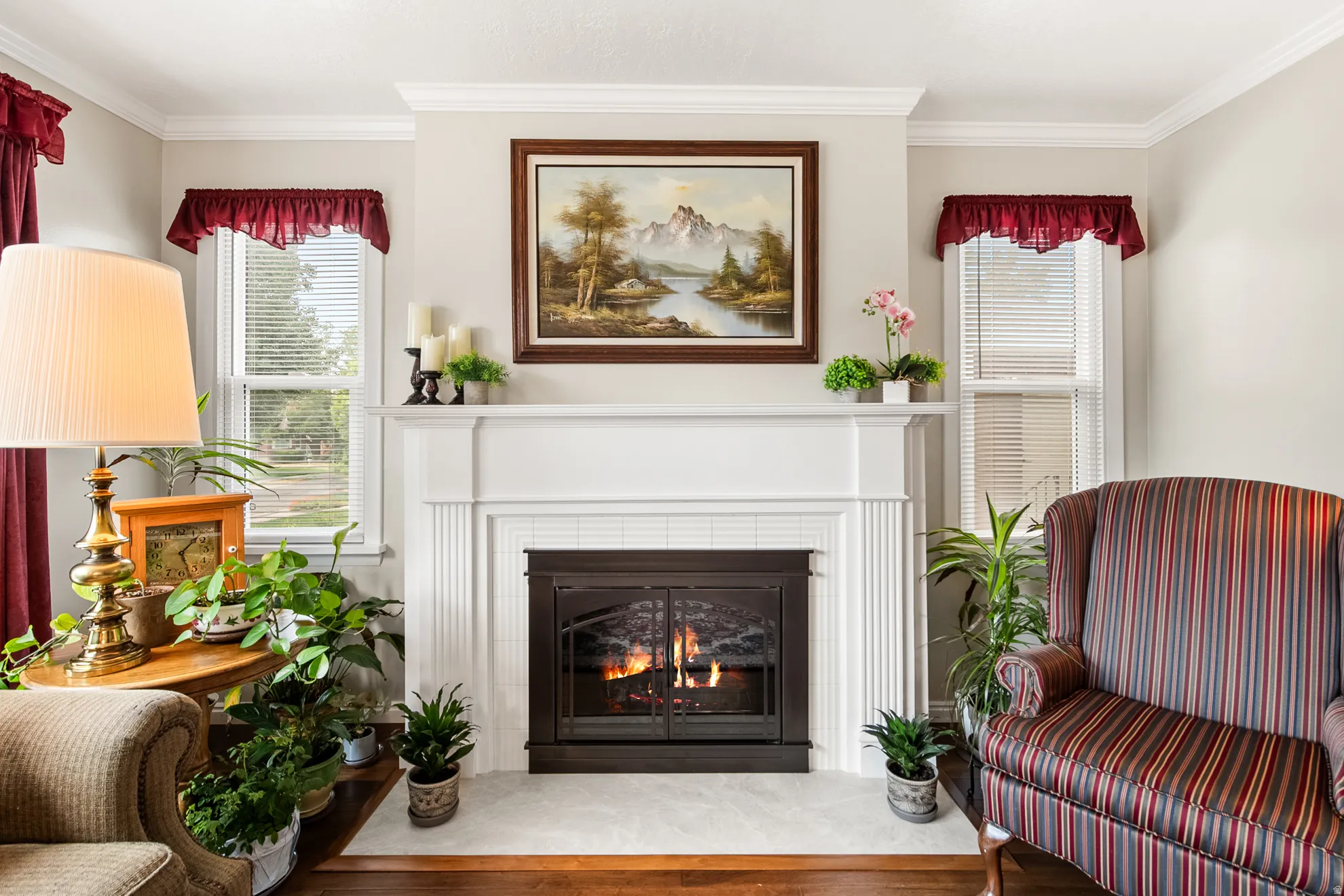 Fireplace with a white mantel and hearth, flanked by two windows with white blinds