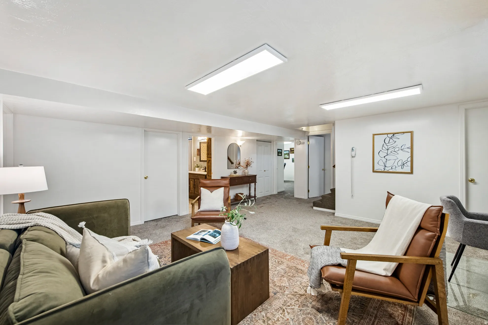 Recessed lighting, carpeted flooring, white interior doors, and a partial view of a vanity with a mirror