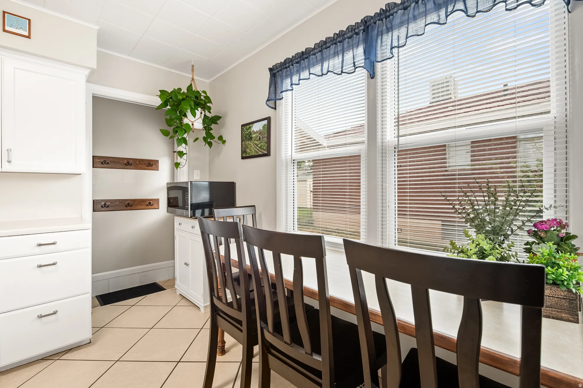 Eat-in kitchen featuring white cabinetry, light-toned countertops, and neutral tile flooring
