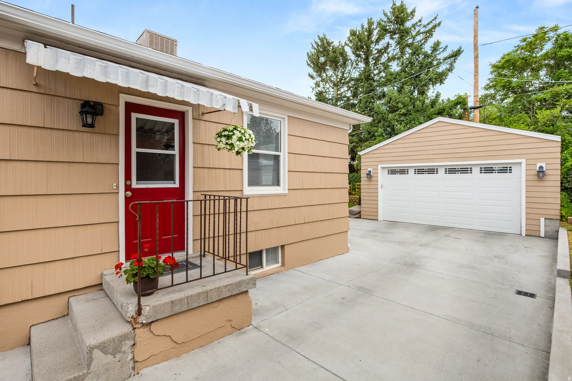 Front entry with a red door, light-colored siding, and concrete steps