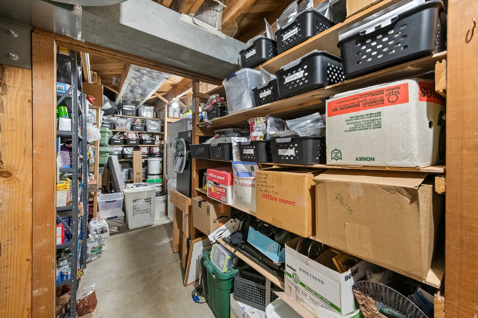 Dedicated storage area featuring wood-beam construction, exposed ceiling joists, and concrete flooring