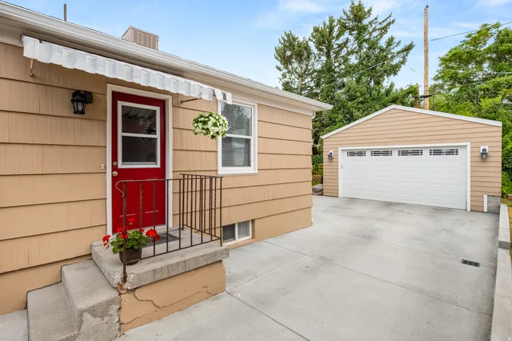 Front entry with a red door, light-colored siding, and concrete steps