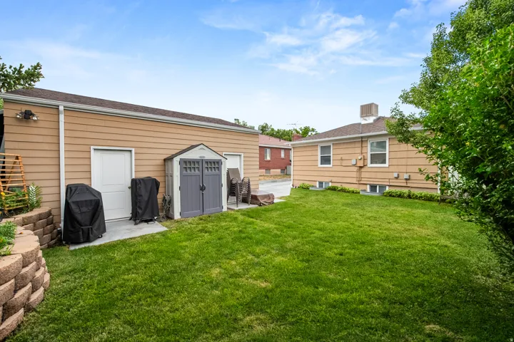 Expansive green lawn with a retaining wall, offering a spacious outdoor area