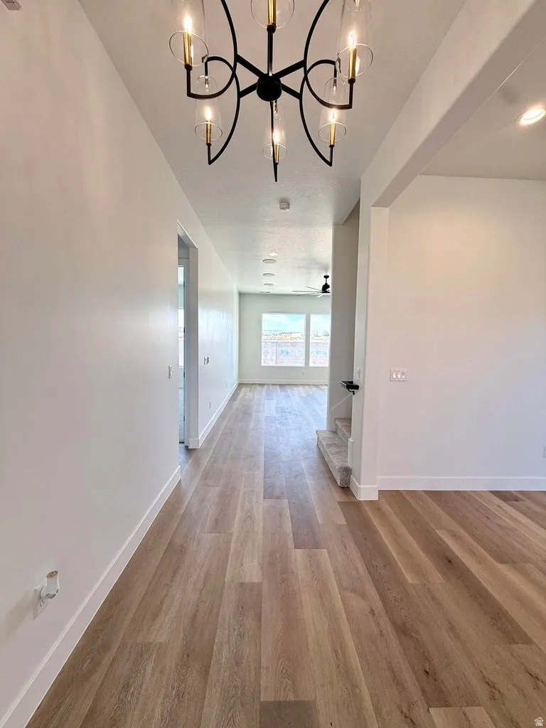 Entryway featuring a modern chandelier, light wood-finish flooring, recessed lighting, and white baseboards