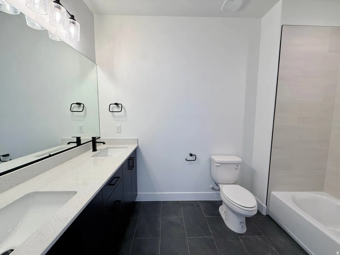 Bathroom featuring a dual vanity with light-colored countertops and undermount sinks
