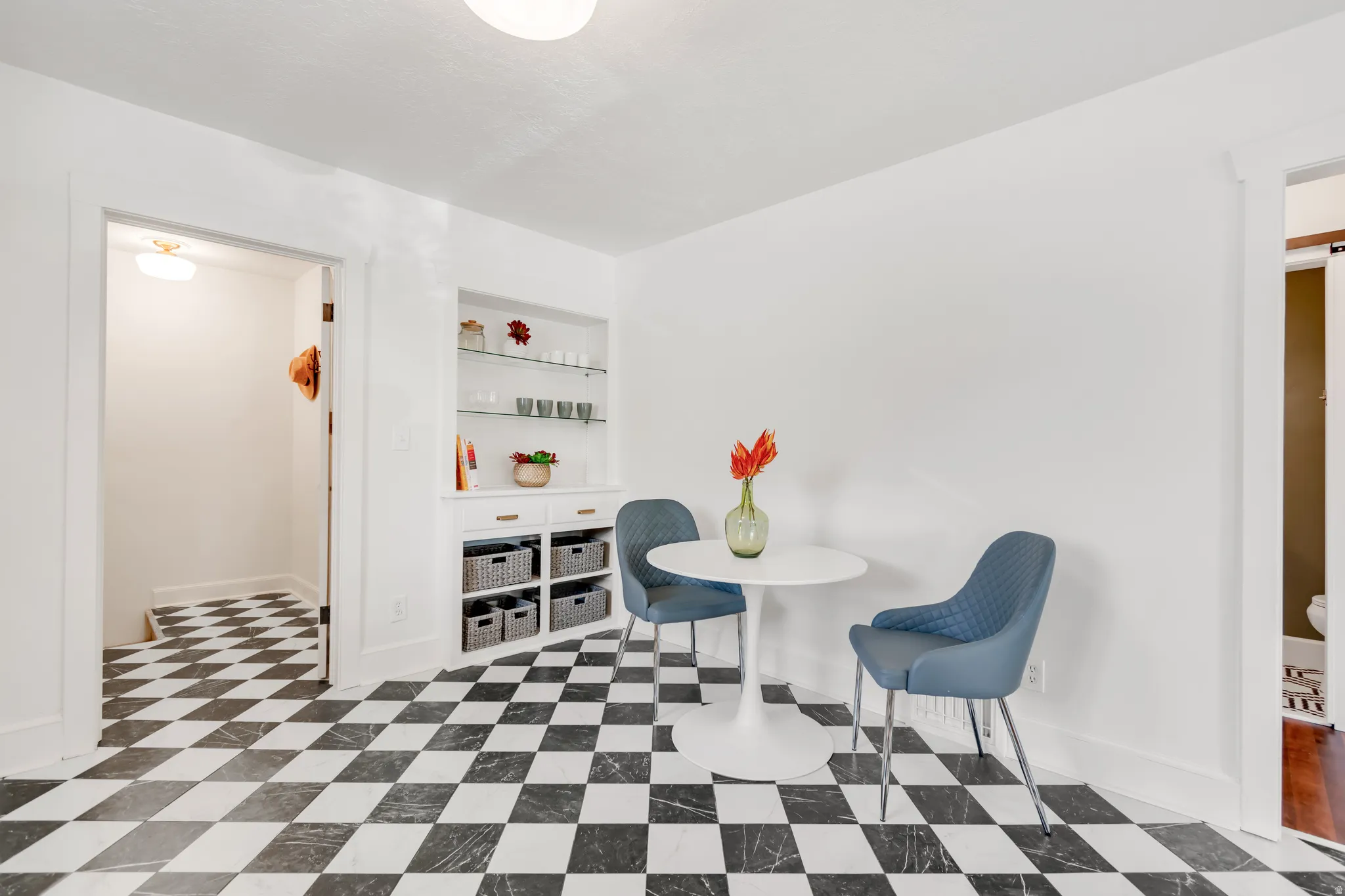 Black and white checkerboard flooring throughout this bright room