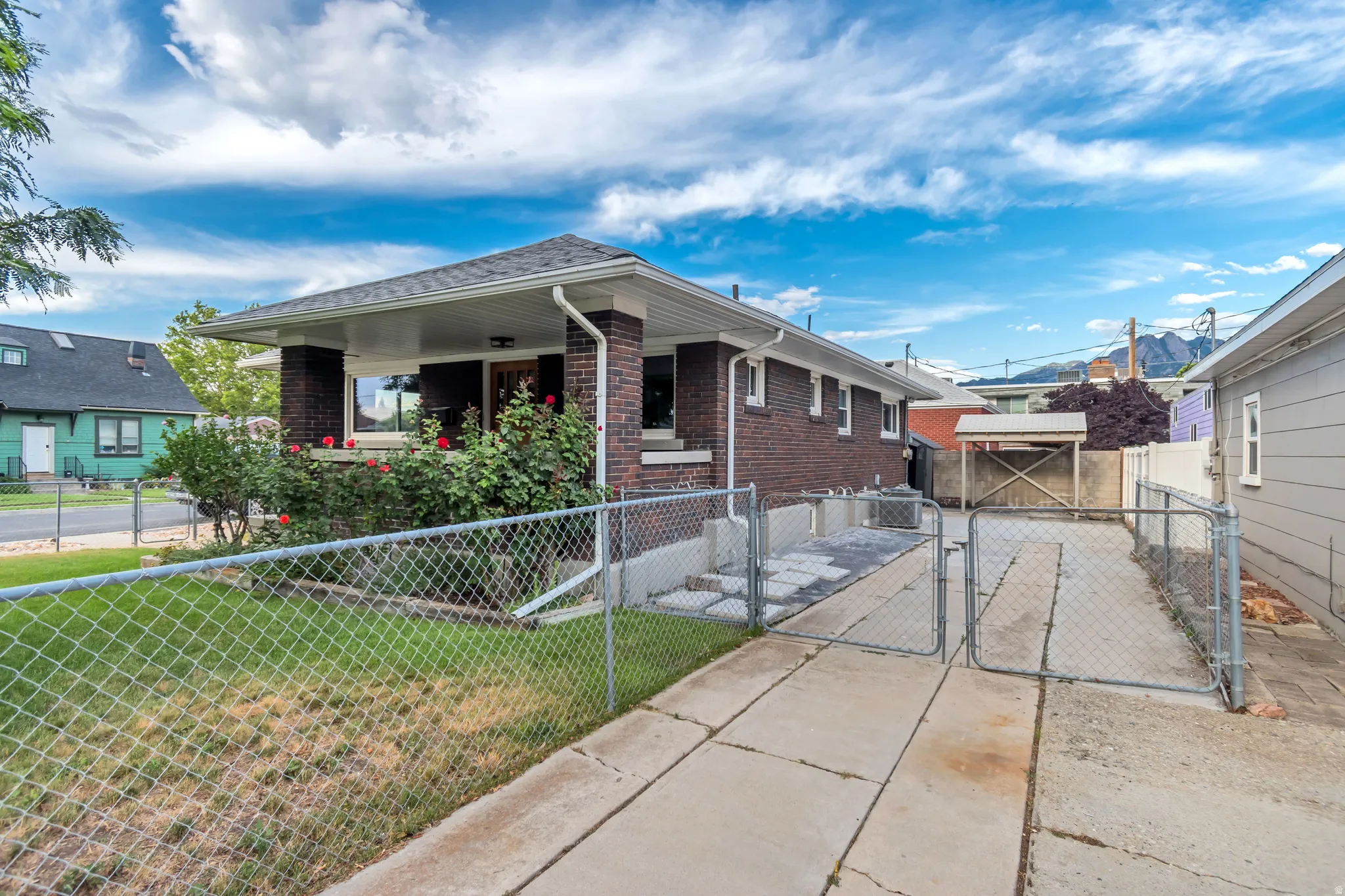 Brick exterior with a covered front porch, established landscaping and RV parking