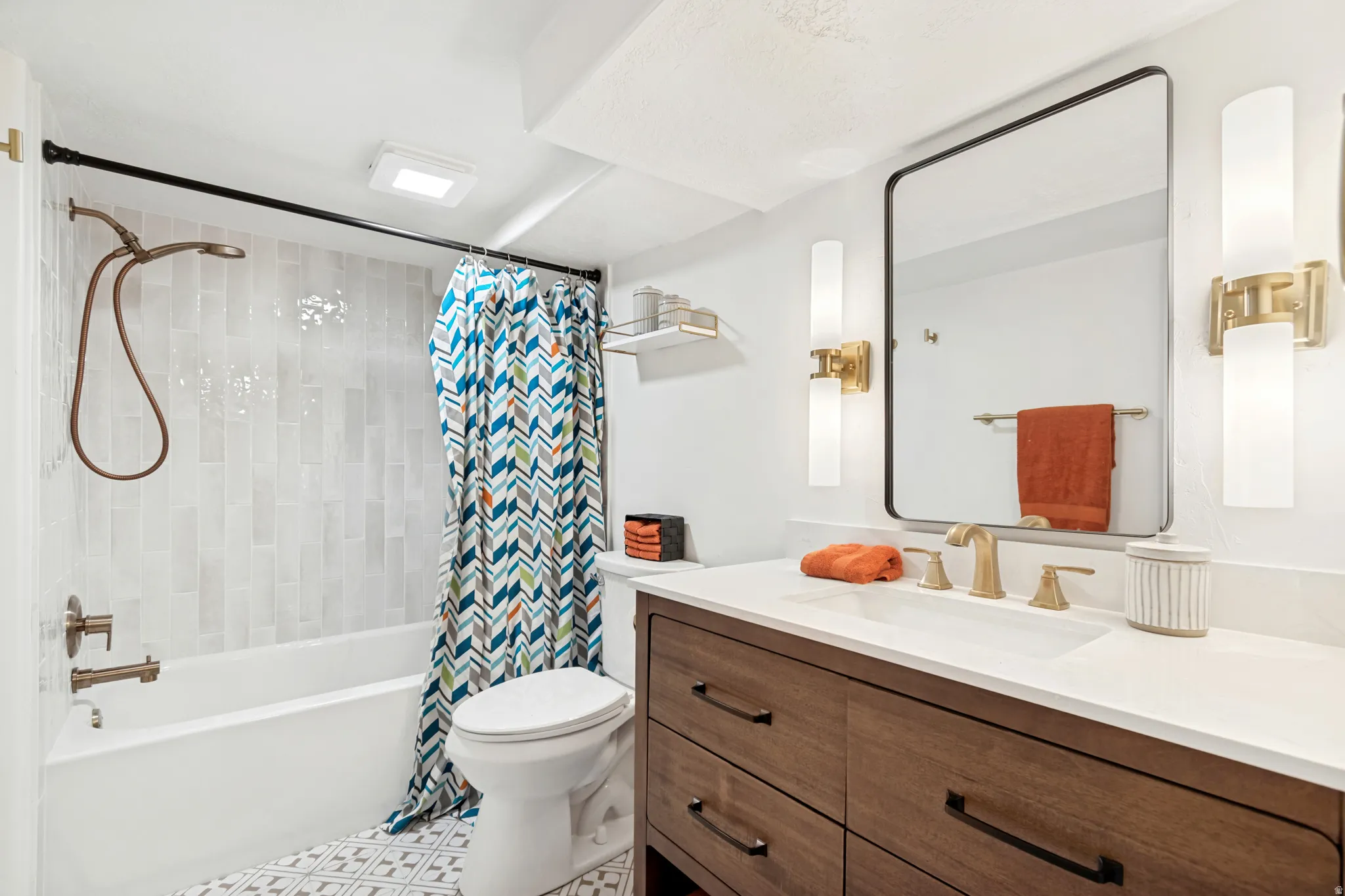 Full Basement Bathroom. Bathroom featuring a wood-finish vanity with a white countertop and undermount sink