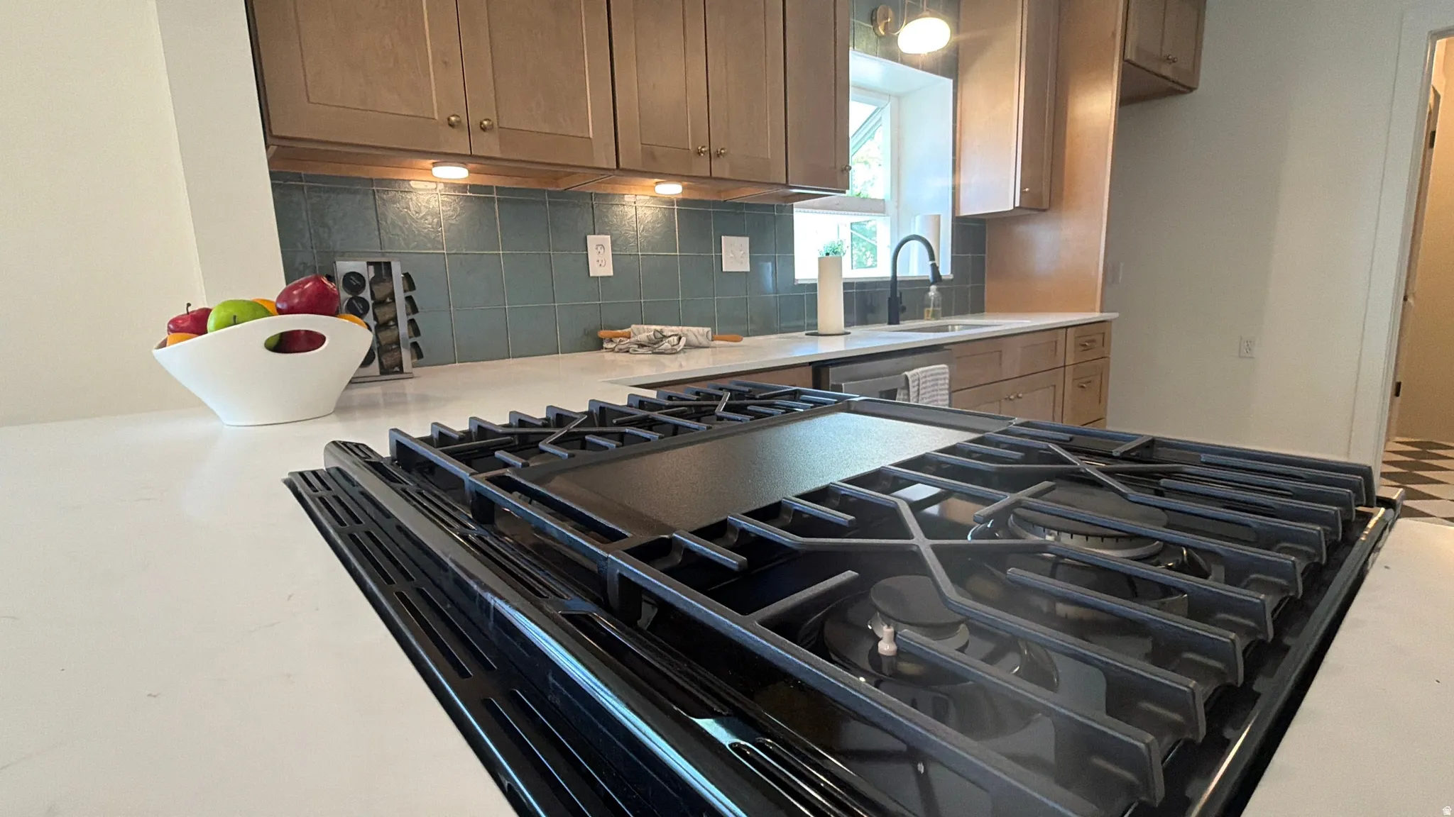 Integrated gas cooktop with griddle, set in a white countertop