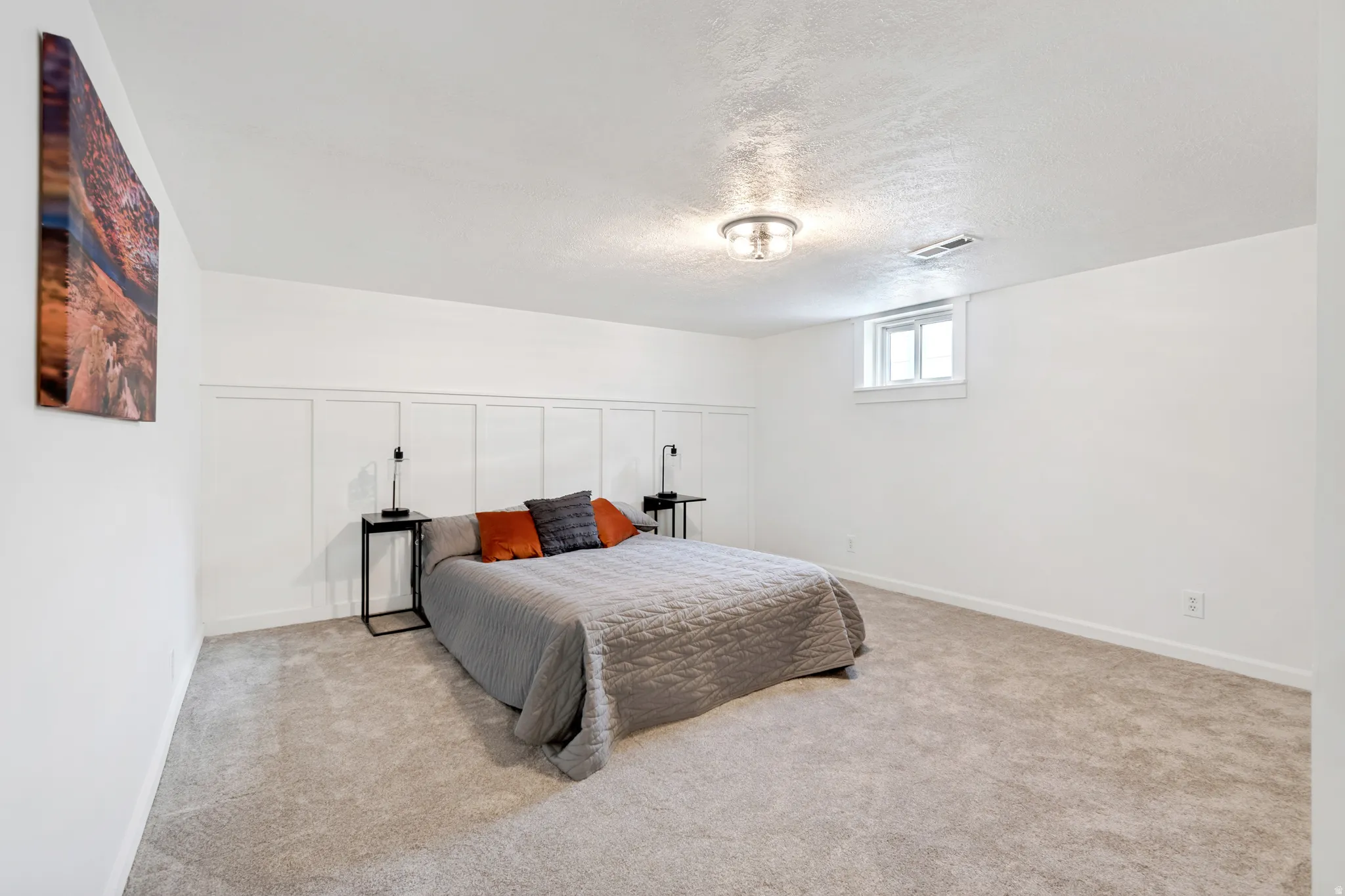 Bedroom 3. Carpeted room featuring a wainscoting accent wall, a flush-mount ceiling light fixture, and a single window