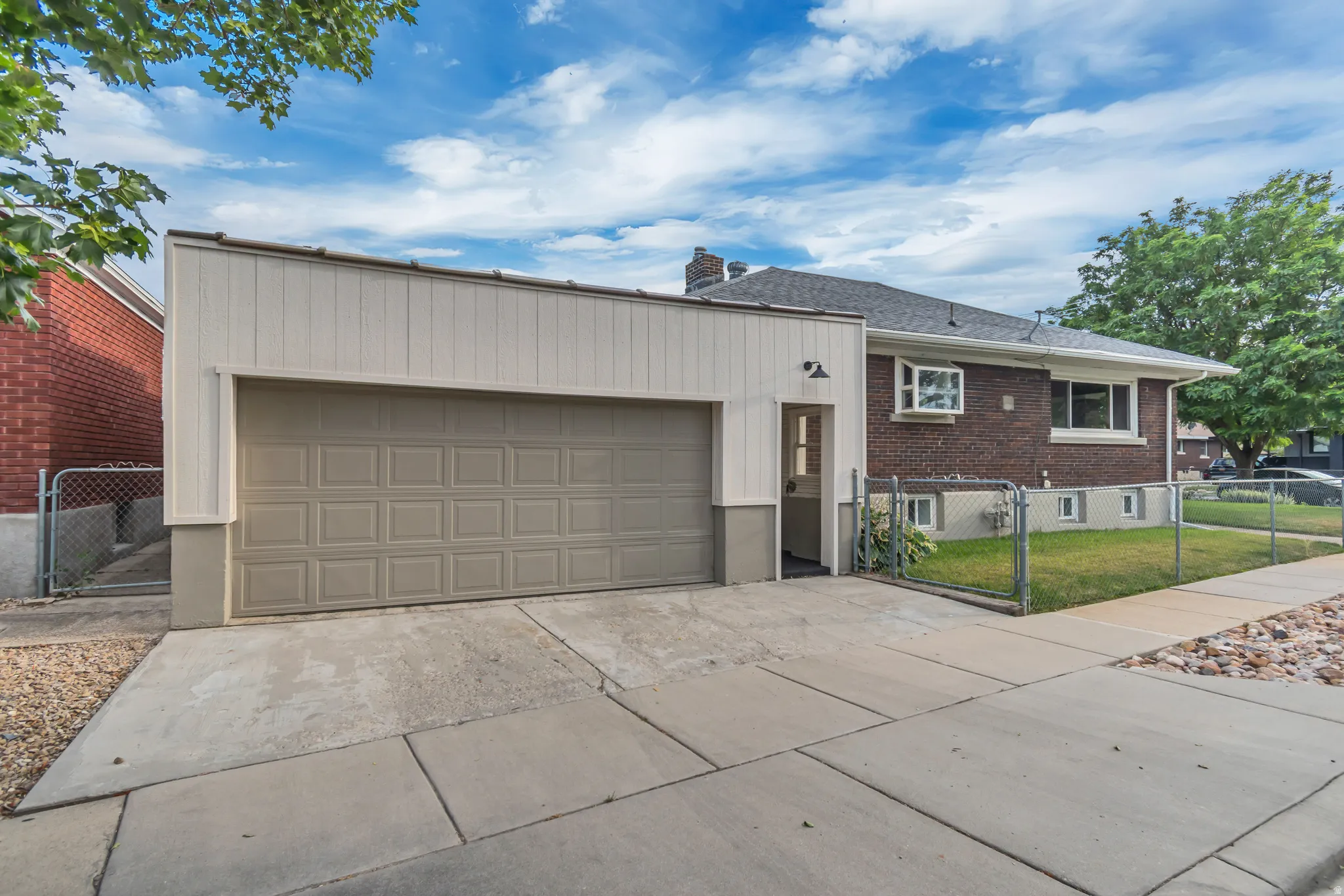 Attached 2-car garage with panel siding, an overhead door, and a dedicated pedestrian entry