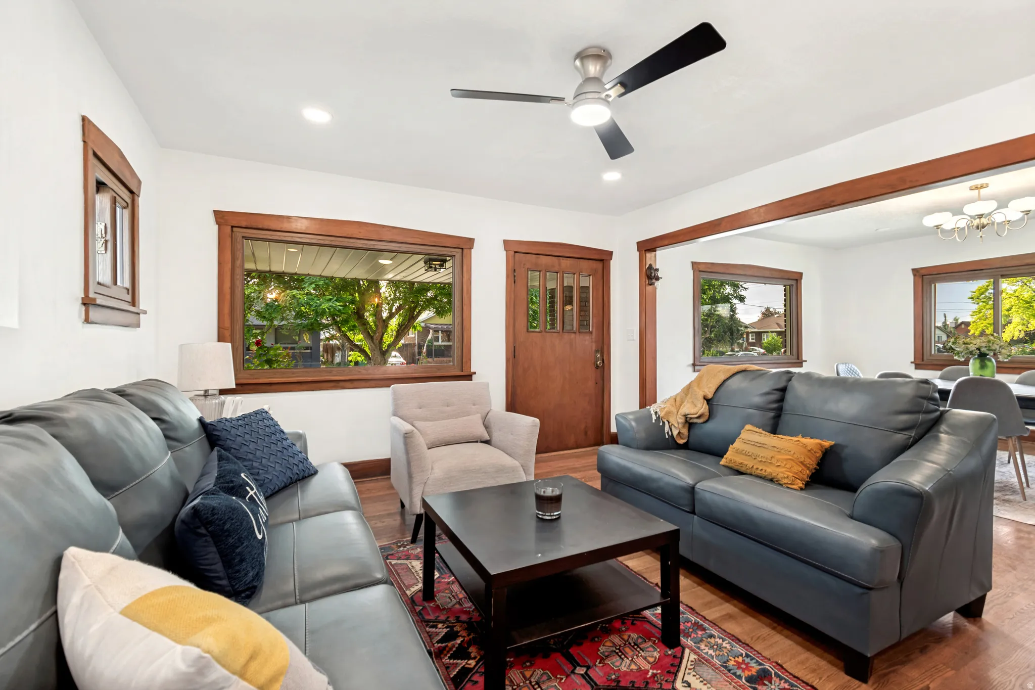 Living area with wood-finish flooring, white walls, and dark wood trim