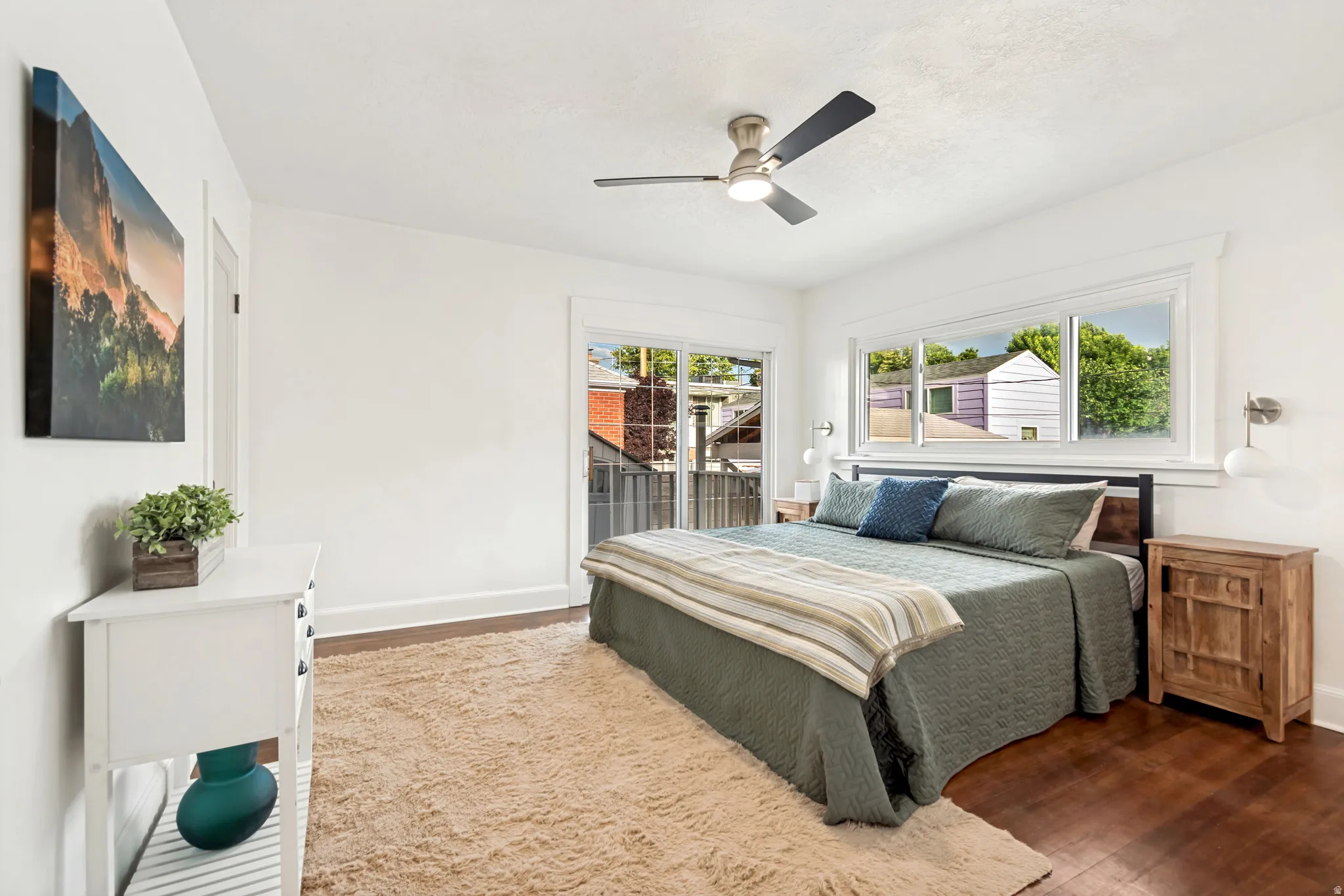 Master Bedroom. Bright interior featuring wood-finish flooring, white walls, and a contemporary ceiling fan with integrated lighting