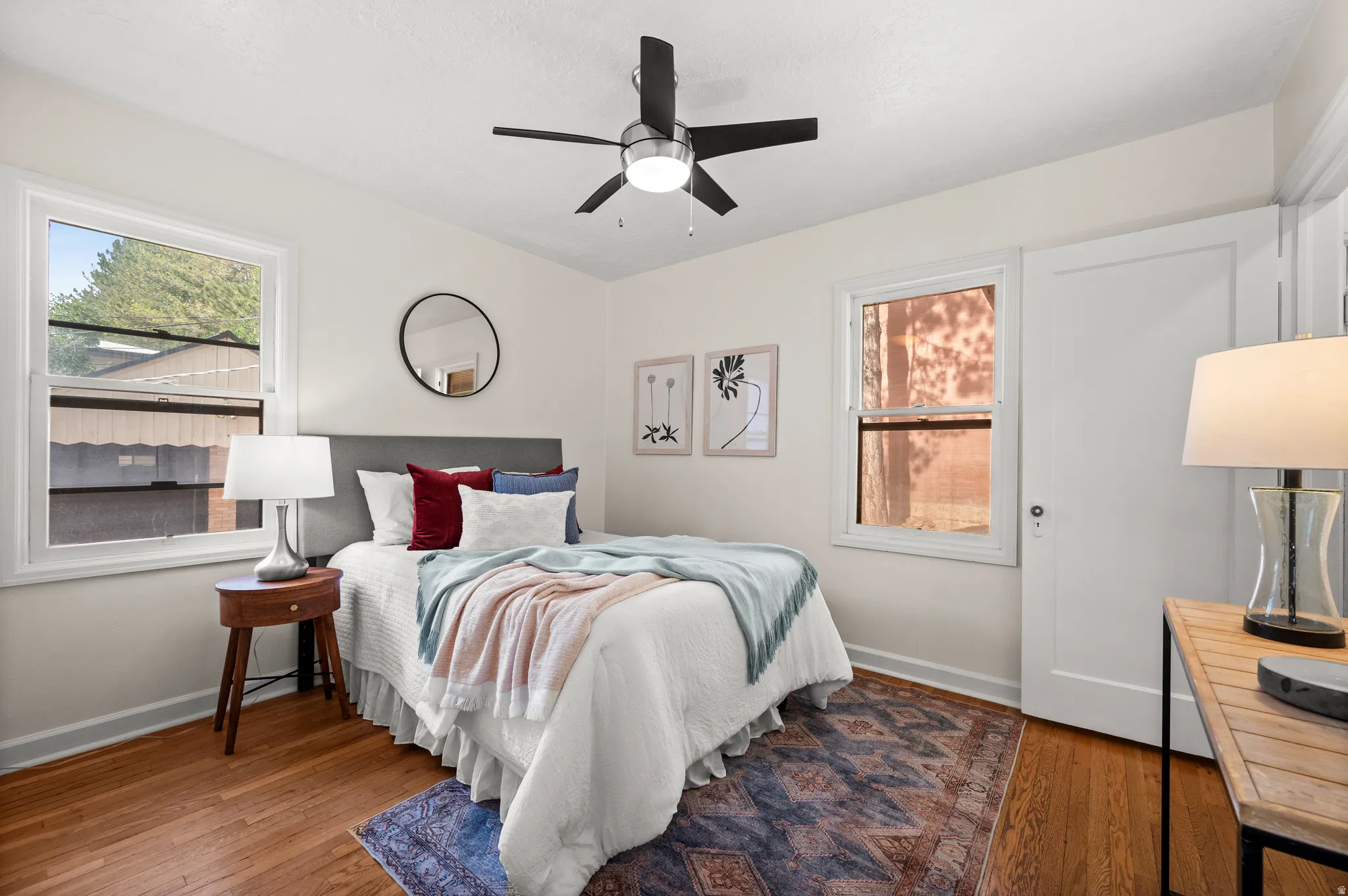 Bright bedroom featuring hardwood flooring and white walls