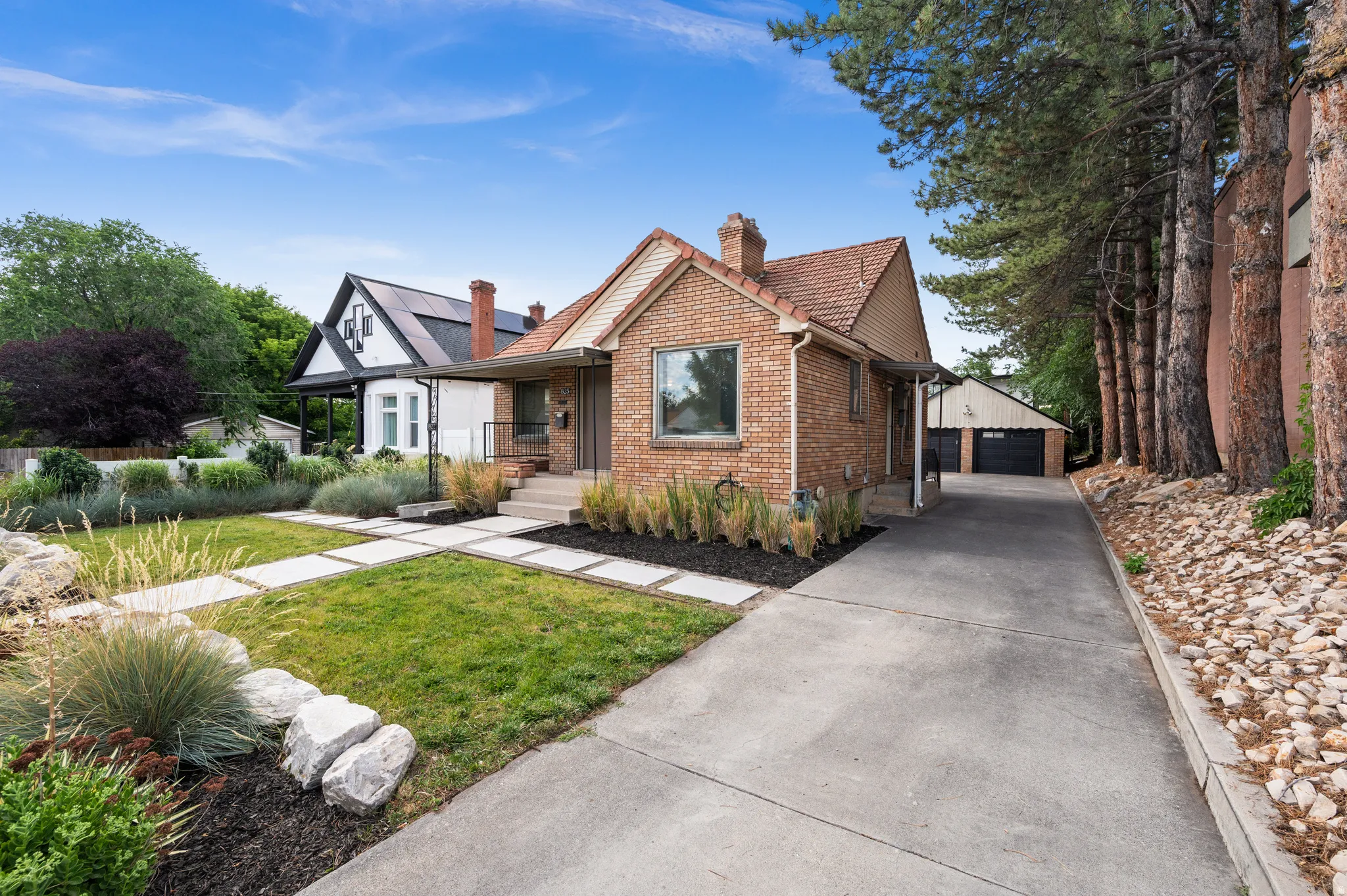 Brick facade residence featuring a tiled roof and a concrete driveway
