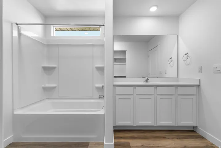 Full bathroom featuring a white tub and shower combination with a transom window