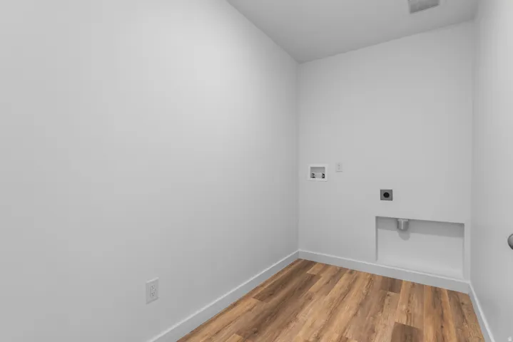 Dedicated utility room with wood-finish flooring and white baseboards