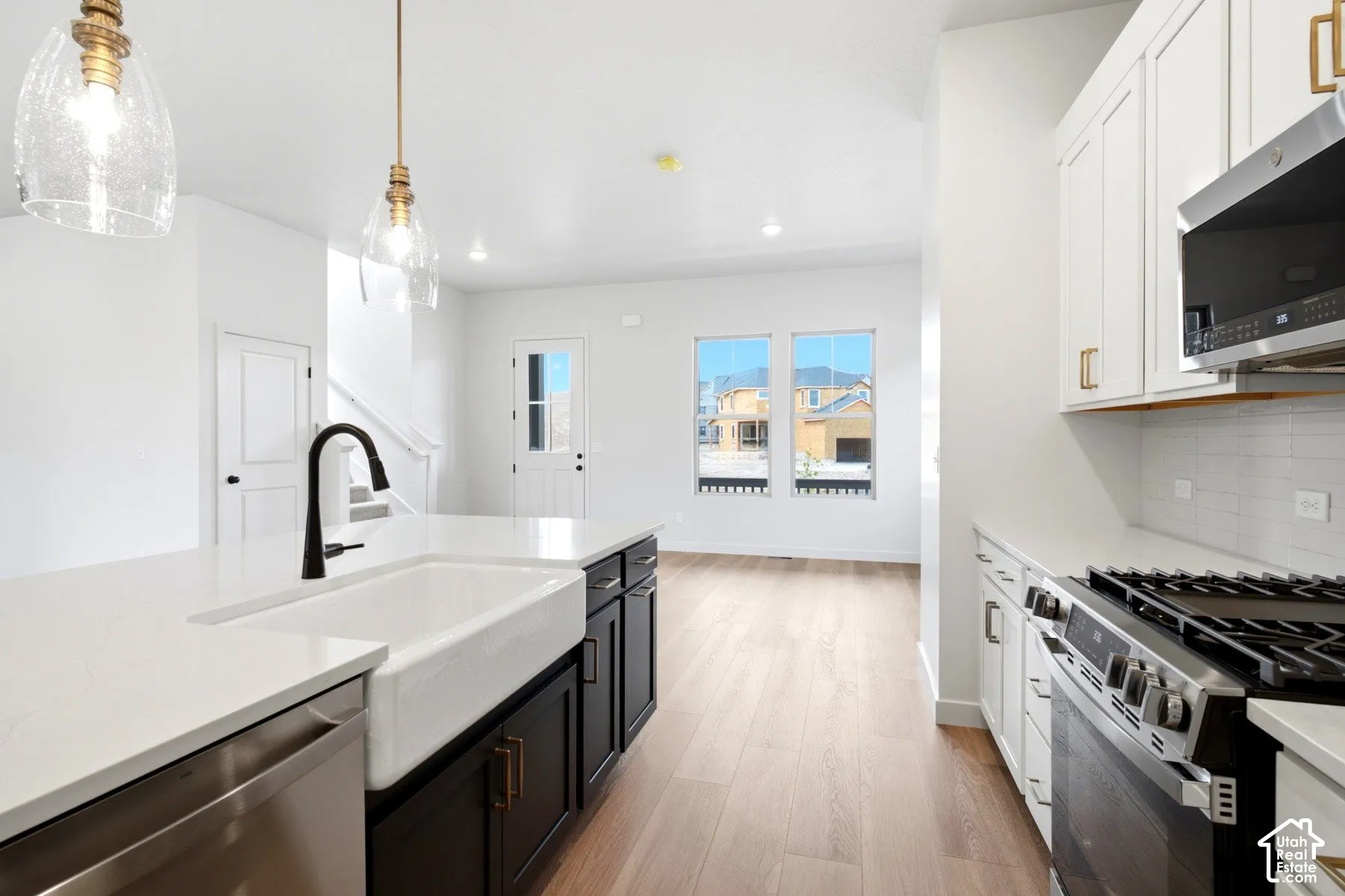 Kitchen island featuring a farmhouse sink and matte black faucet