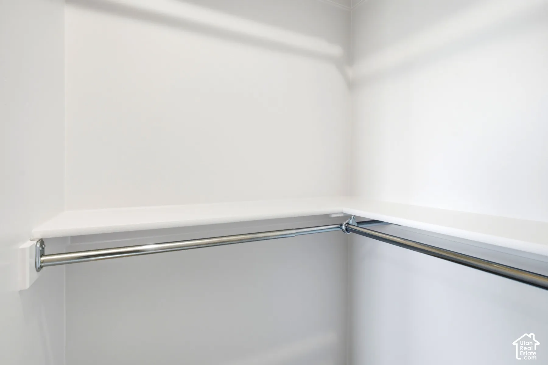Corner closet with integrated shelving and chrome hanging rods