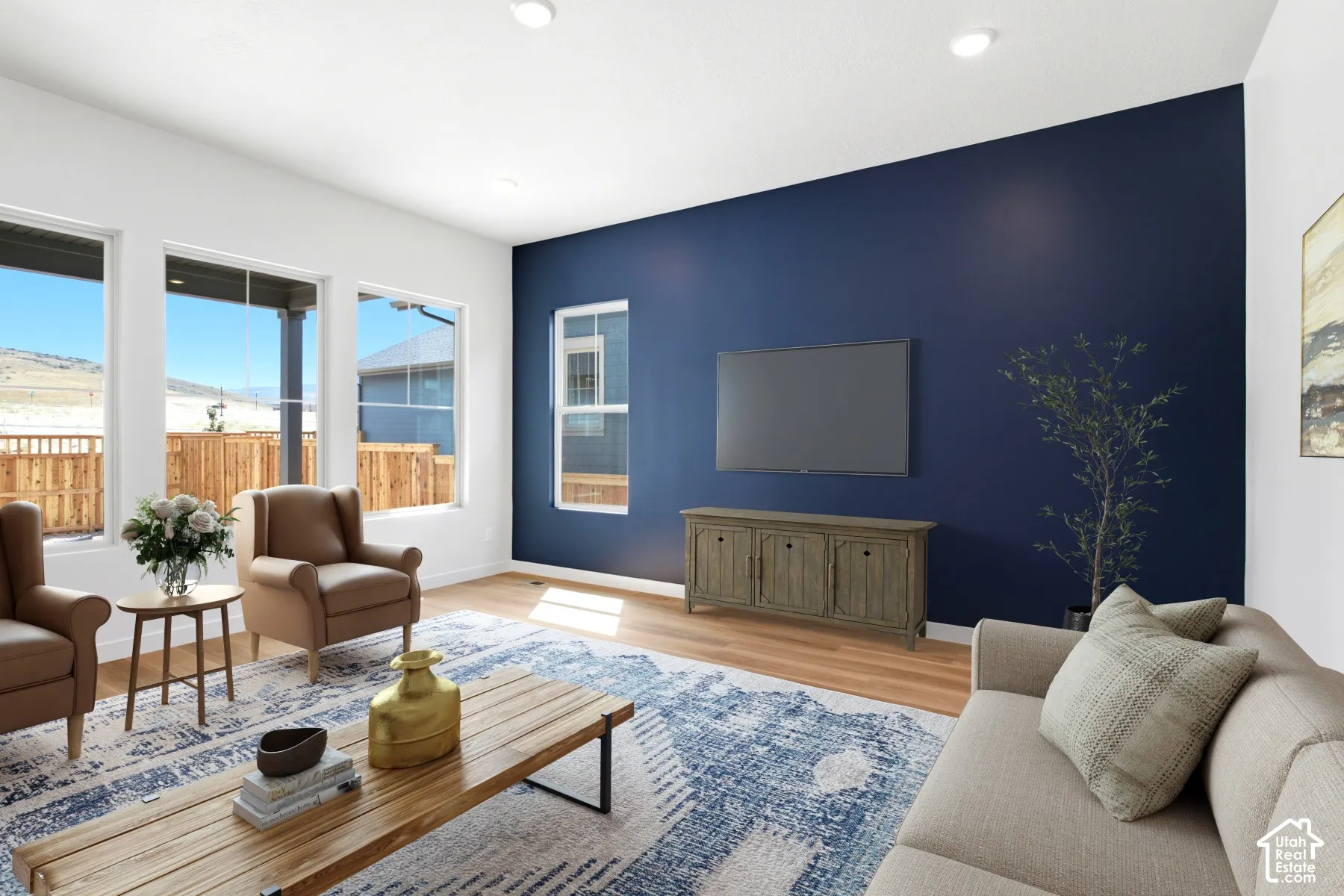 Open living space featuring wood-finish flooring and a distinctive accent wall