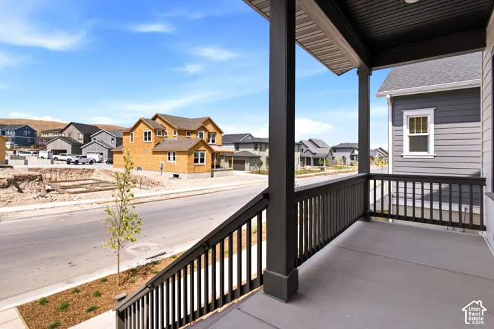 Covered porch featuring dark-stained wood posts and railings