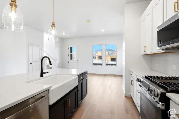 Kitchen island featuring a farmhouse sink and matte black faucet